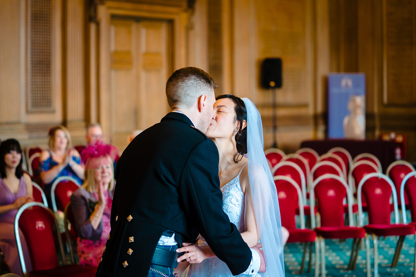husband and wife kiss after getting married in the civic hall