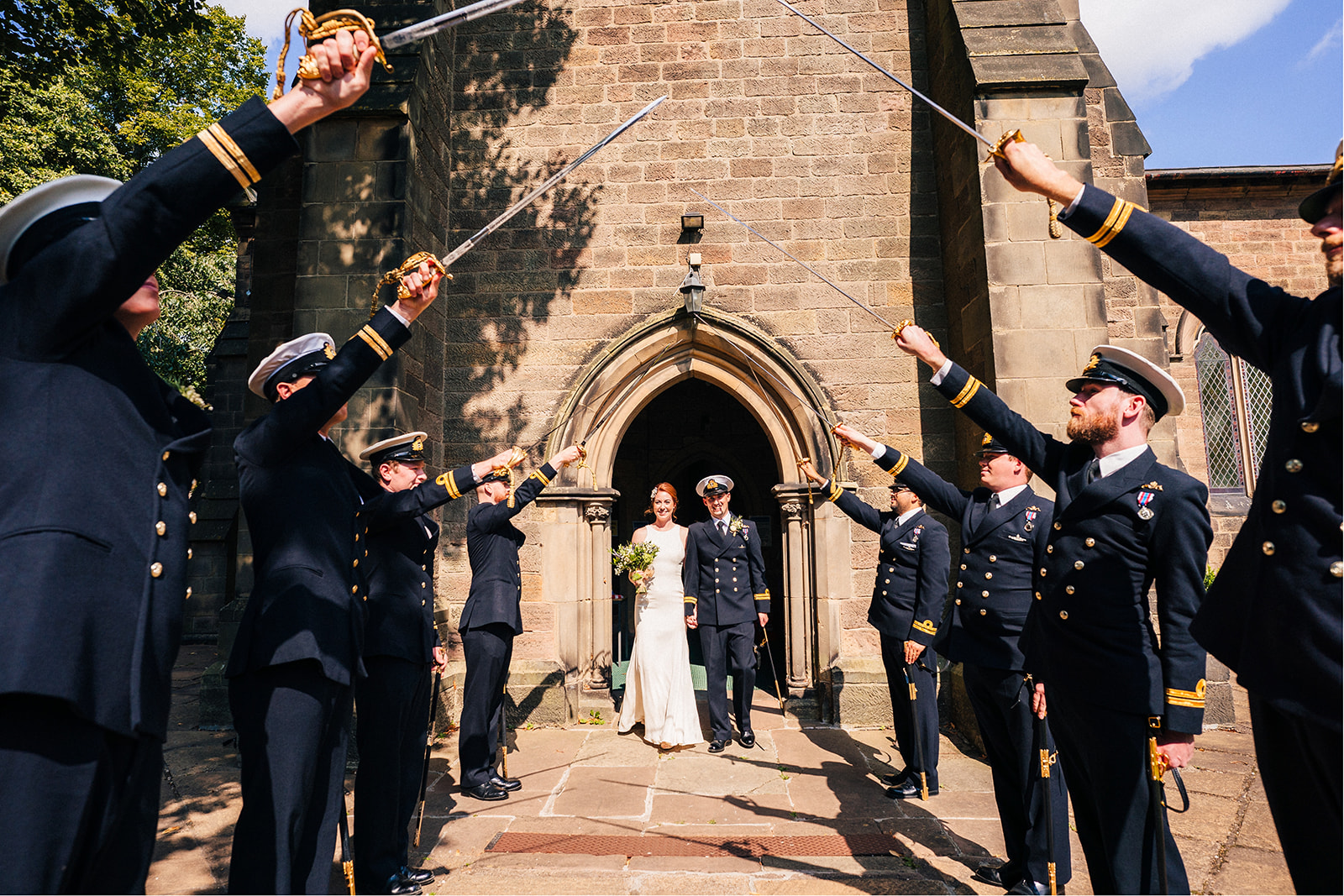 Derby DIY Farm Wedding Photography - the naval officers raising their swords to the bride and groom
