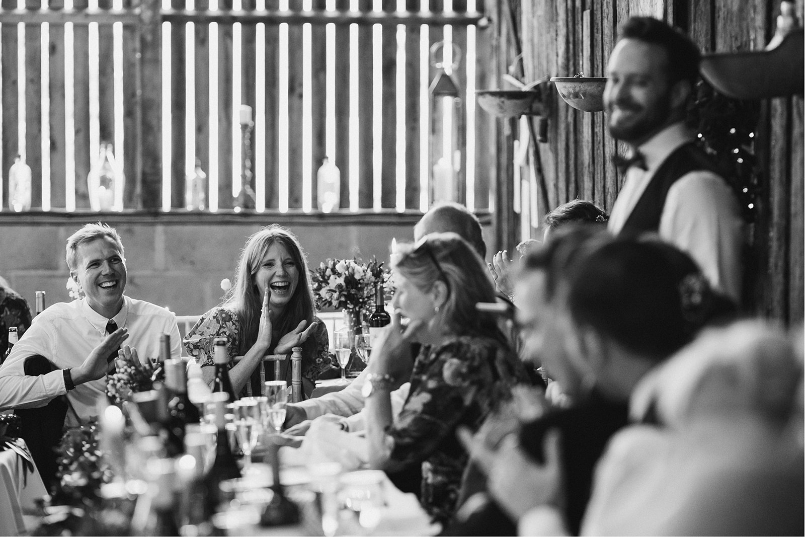 Derby DIY Farm Wedding Photography - a wedding guest laughing at the wedding speeches
