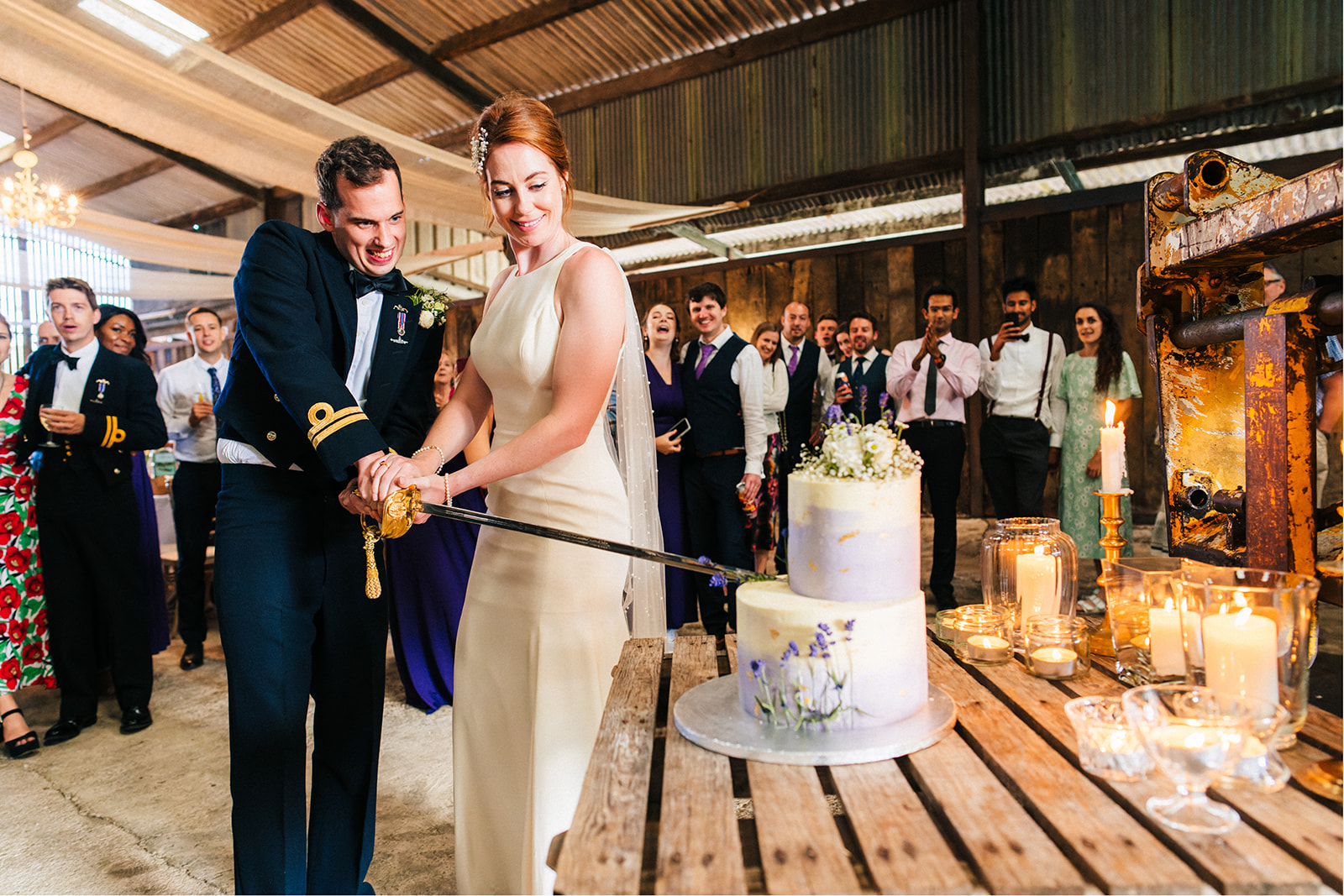 Derby DIY Farm Wedding Photography - bride and groom cut the wedding cake with a sword
