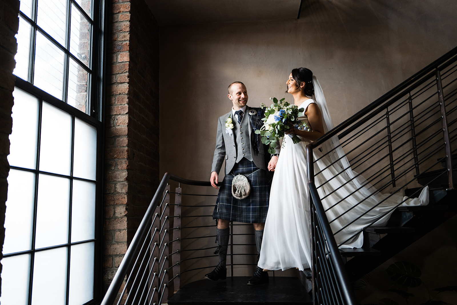 bride and groom coming down the staircase with beautiful window light pouring in, engine works glasgow