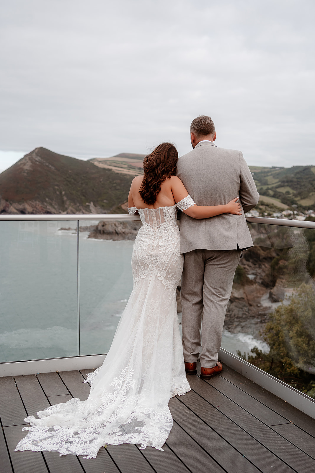 Back view of the bride and groom looking out over the view across the sea at their Sandy Cove Hotel wedding