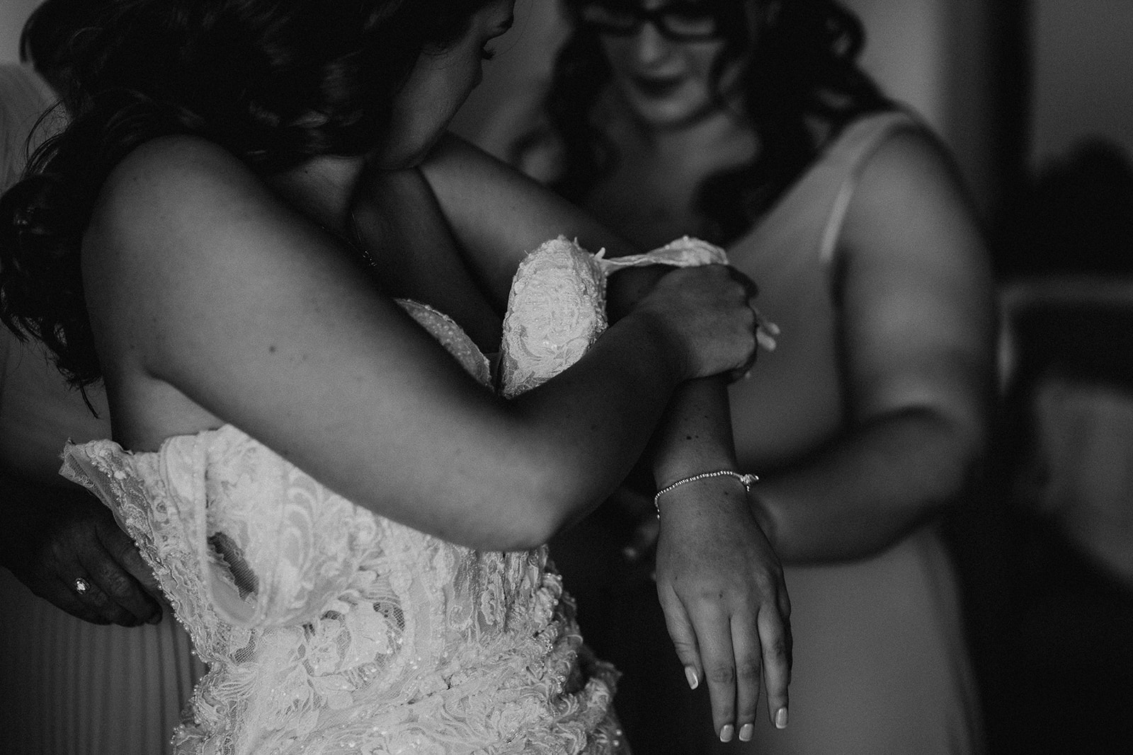black and white photo of bride putting on her wedding dress at a Sandy Cove Hotel wedding