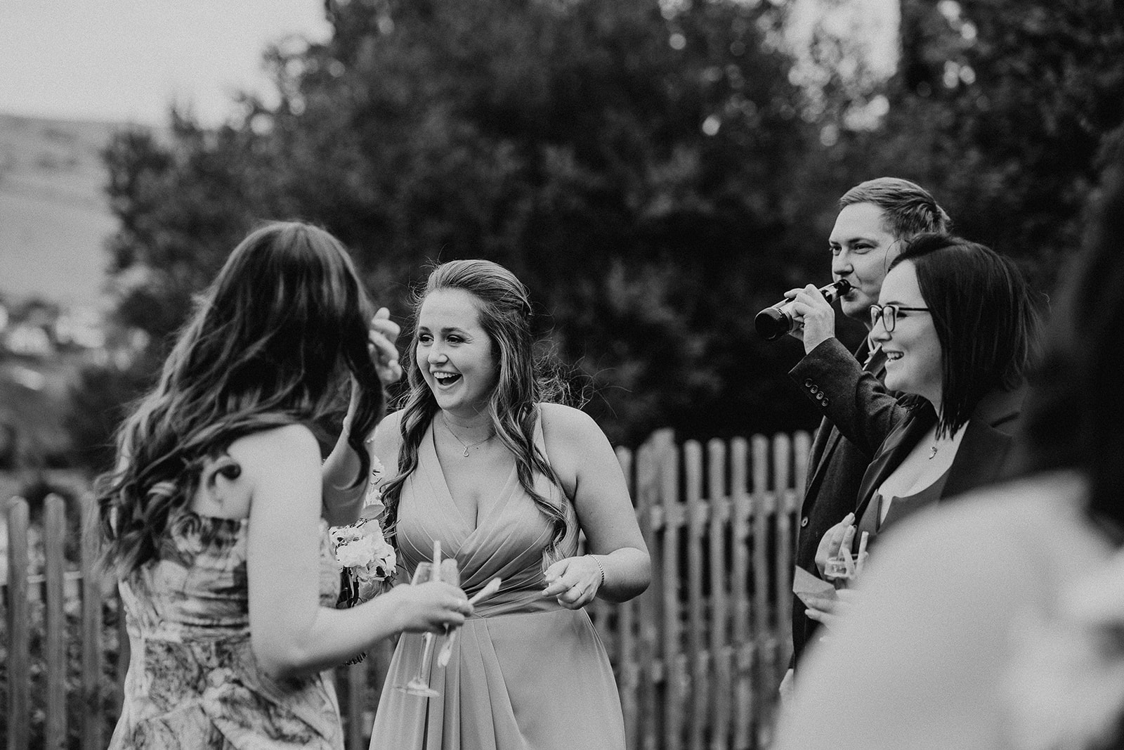 black and white photo of wedding guests laughing at a Sandy Cove Hotel wedding