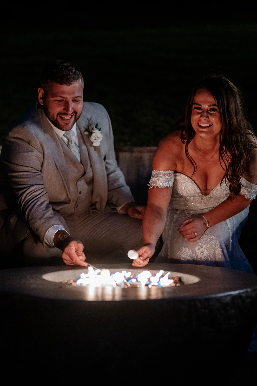 Bride and groom toast marshmallows on the firepit at night - Sandy Cove Hotel wedding photography
