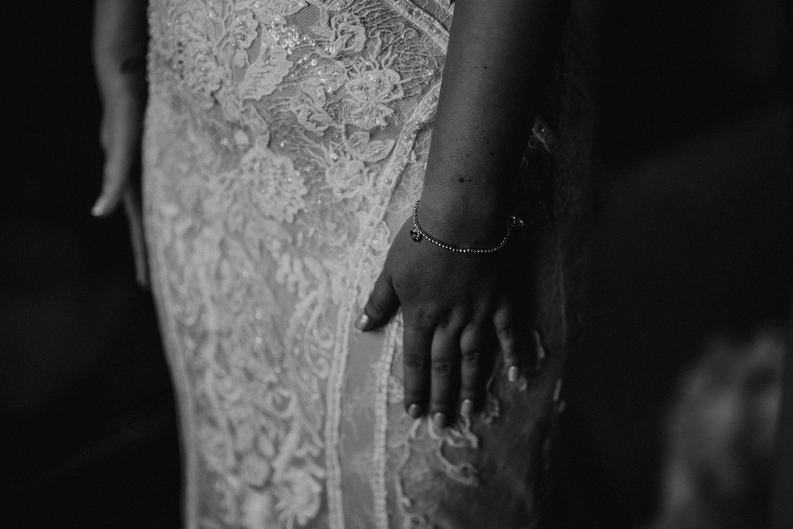 bride's hand rests against her lacy wedding dress at a Sandy Cove Hotel wedding