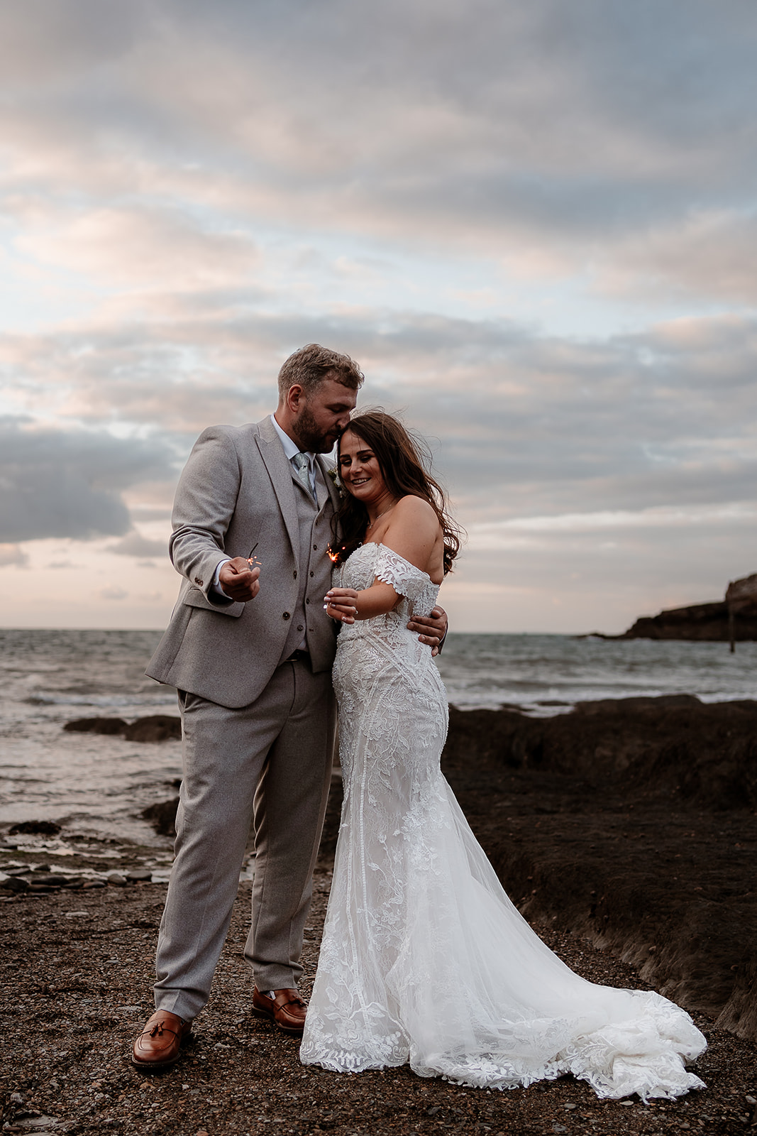 Portrait of bride and groom with their sparklers at their Sandy Cove Hotel wedding