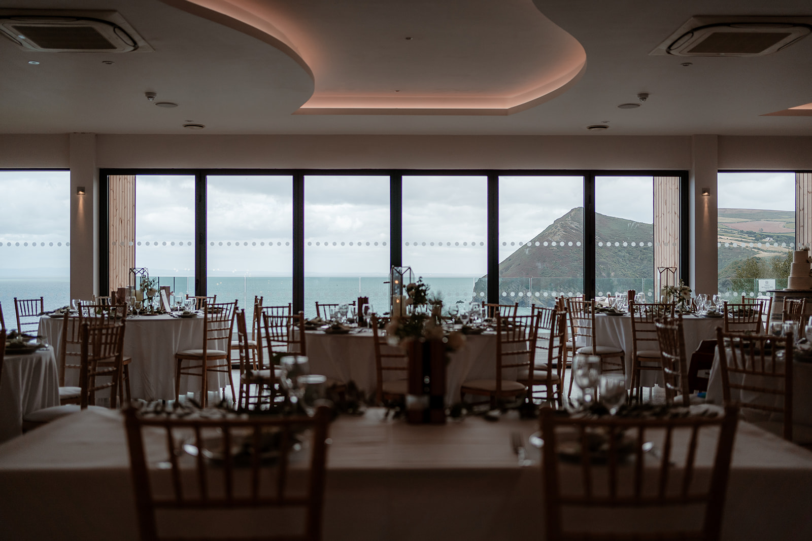 View from the sweetheart table looking over the wedding breakfast room and views through the windows at Sandy Cove Hotel