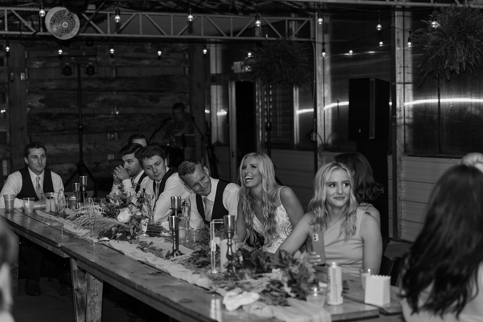 Bride and groom laugh during dinner