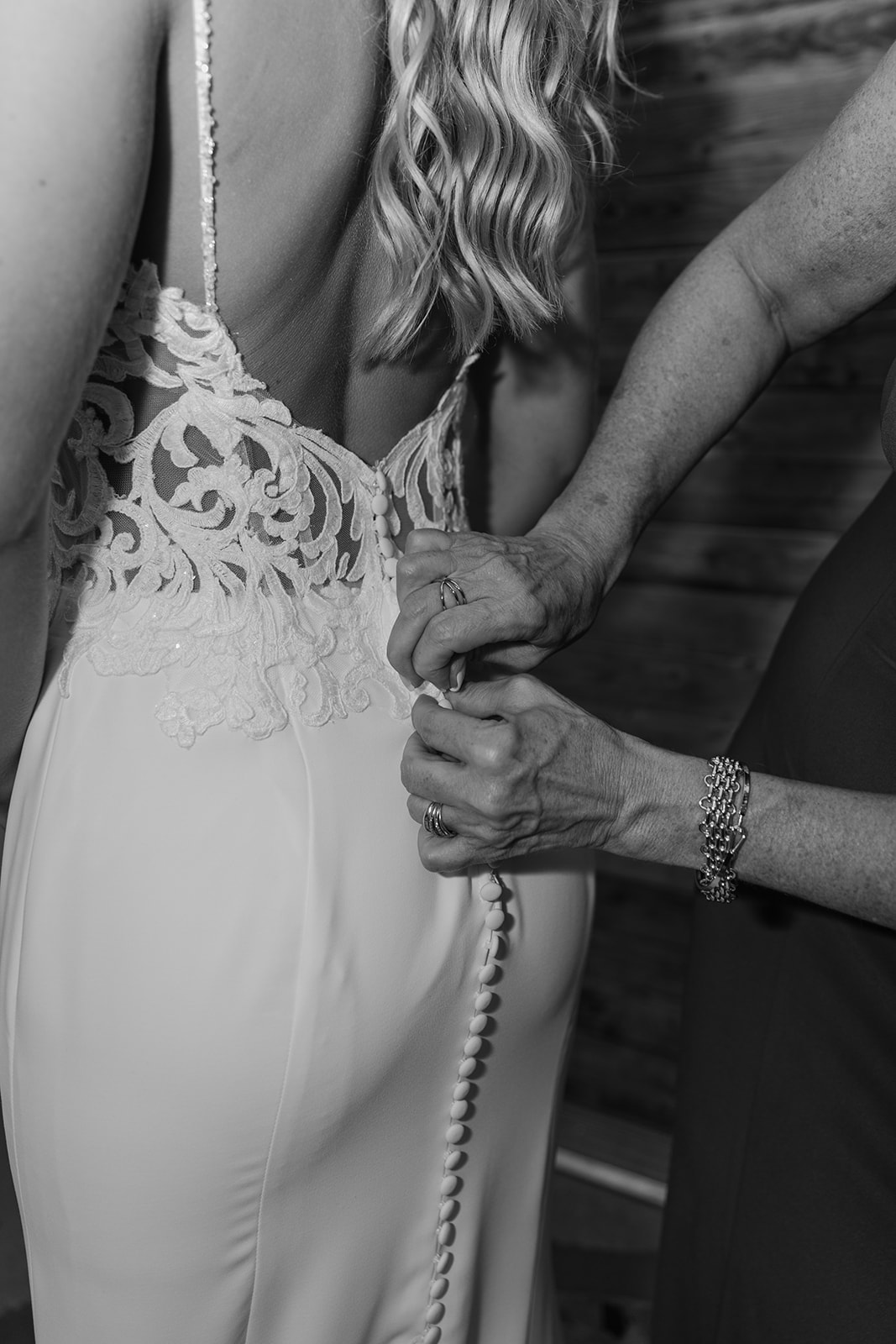 Mother buttons her daughter's wedding dress