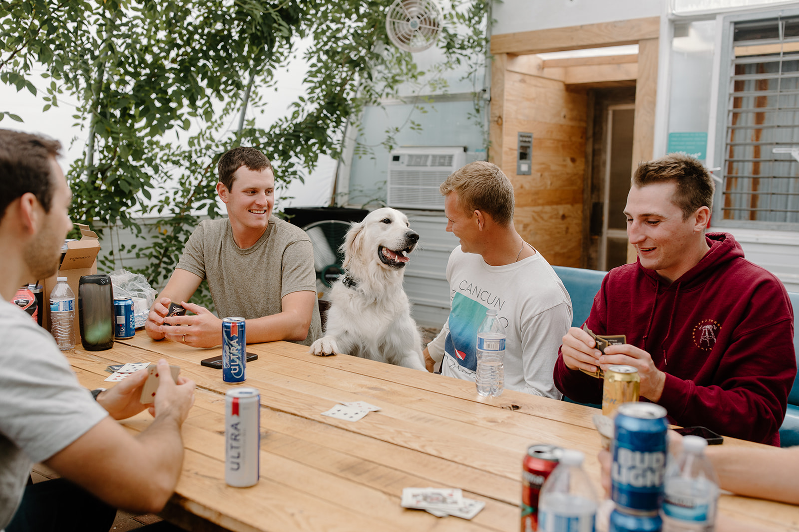 Groom hangs out with his friends and dog while playing cards