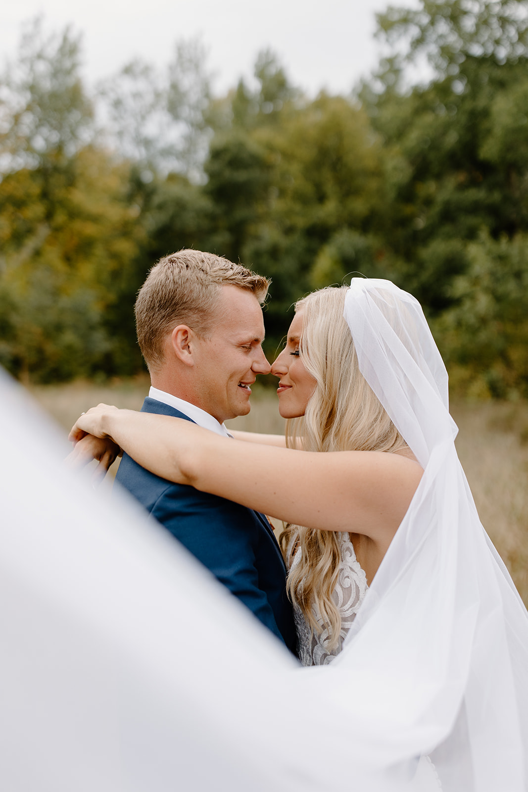 Bride and groom kiss behind the veil