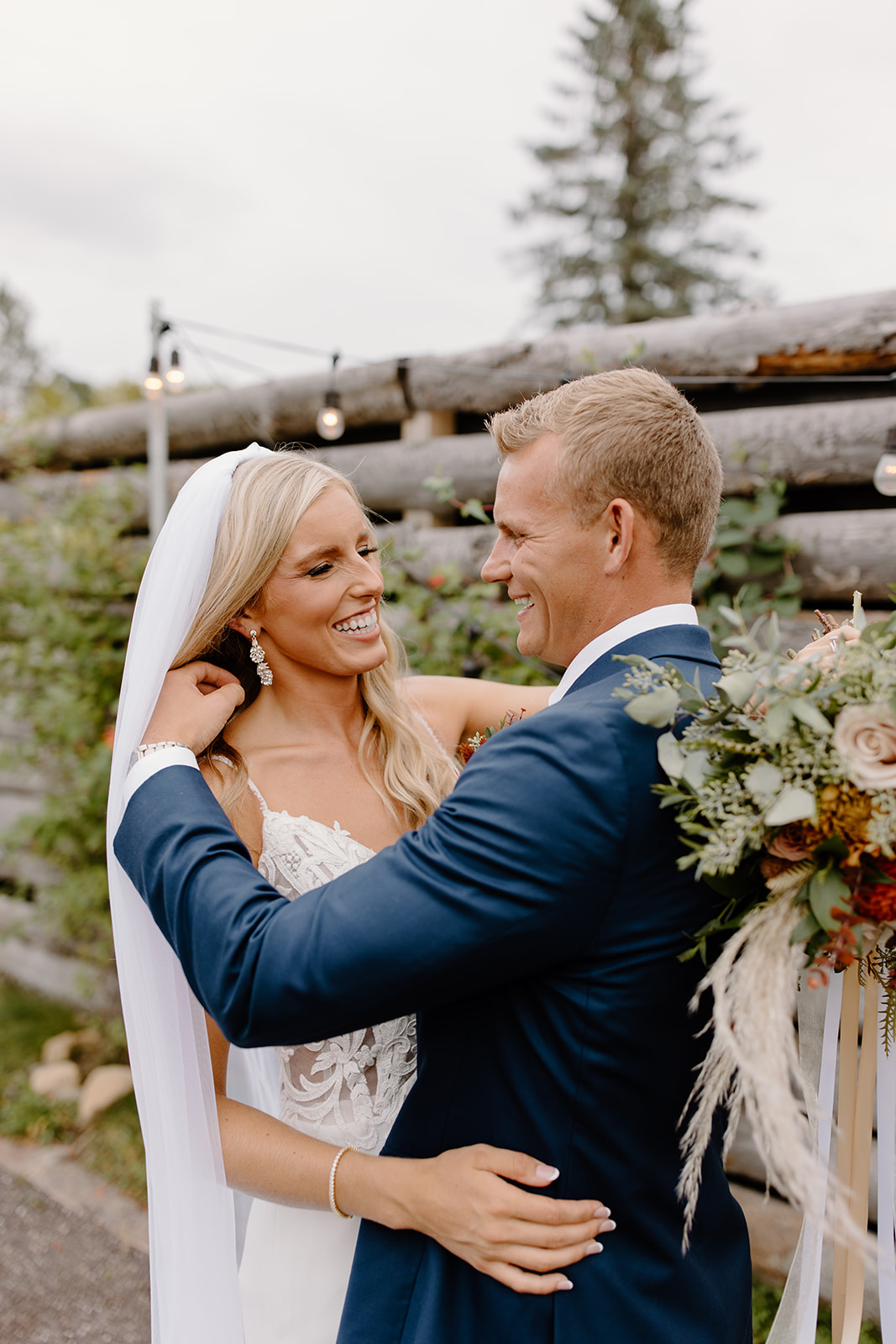 Groom fixes his bride's hair while she smiles at him