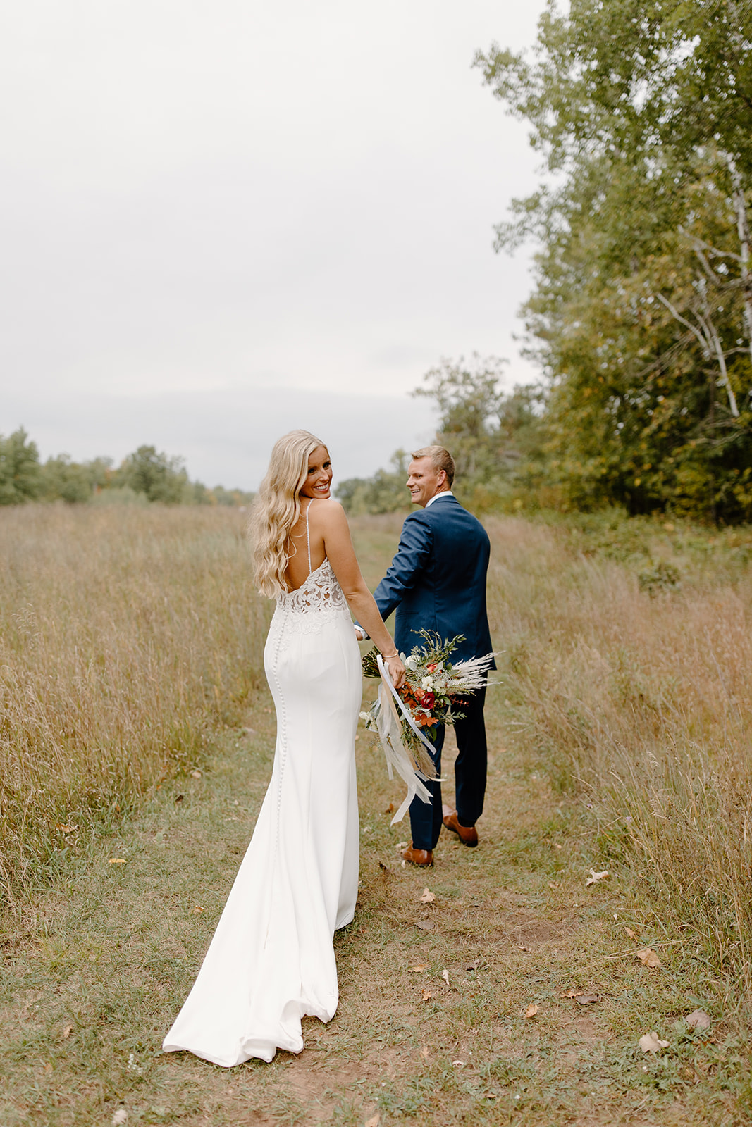 Groom leads his bride up a trail
