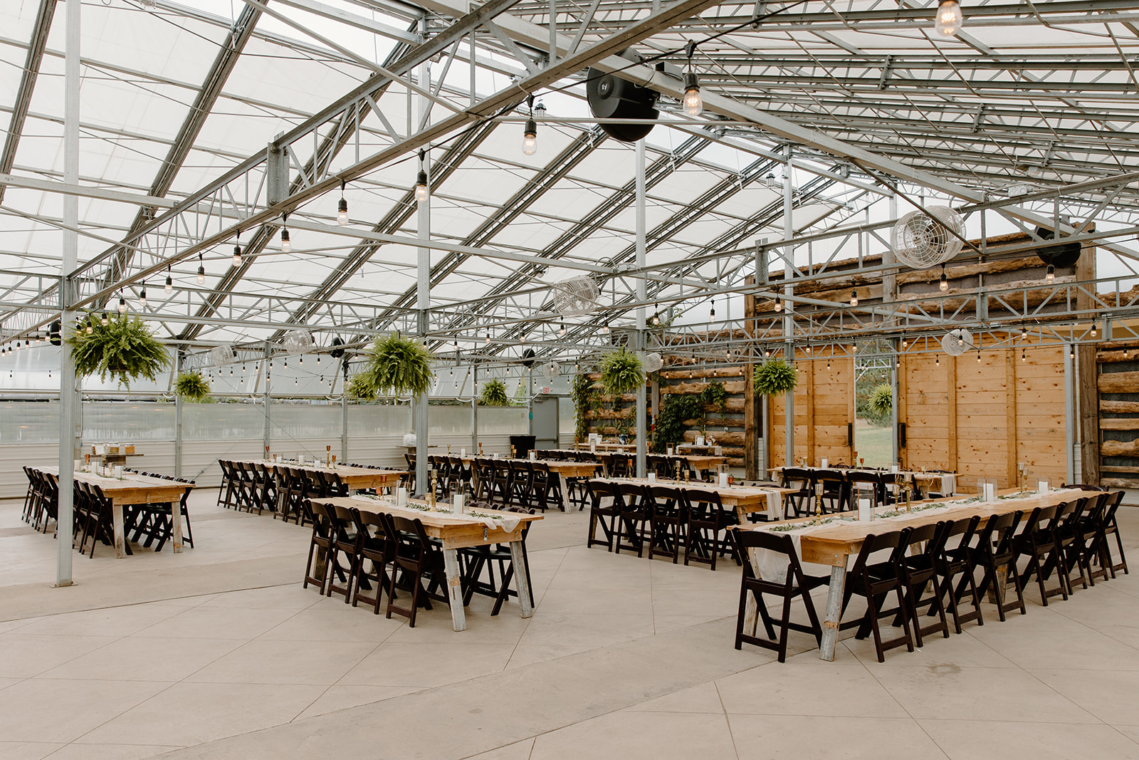 Wedding reception tables inside of a greenhouse