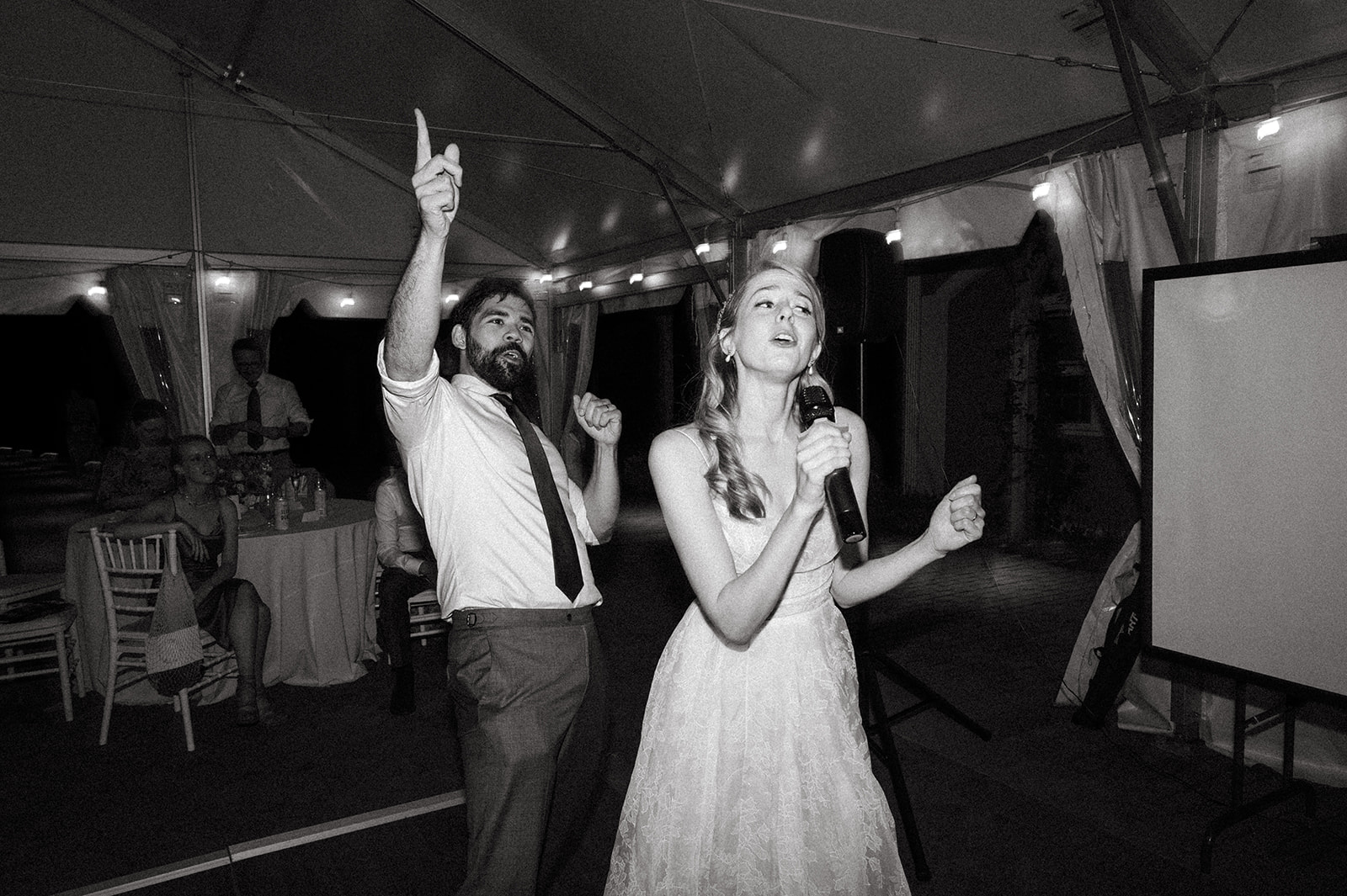 Bride sings karaoke during tented wedding reception at Long Hill