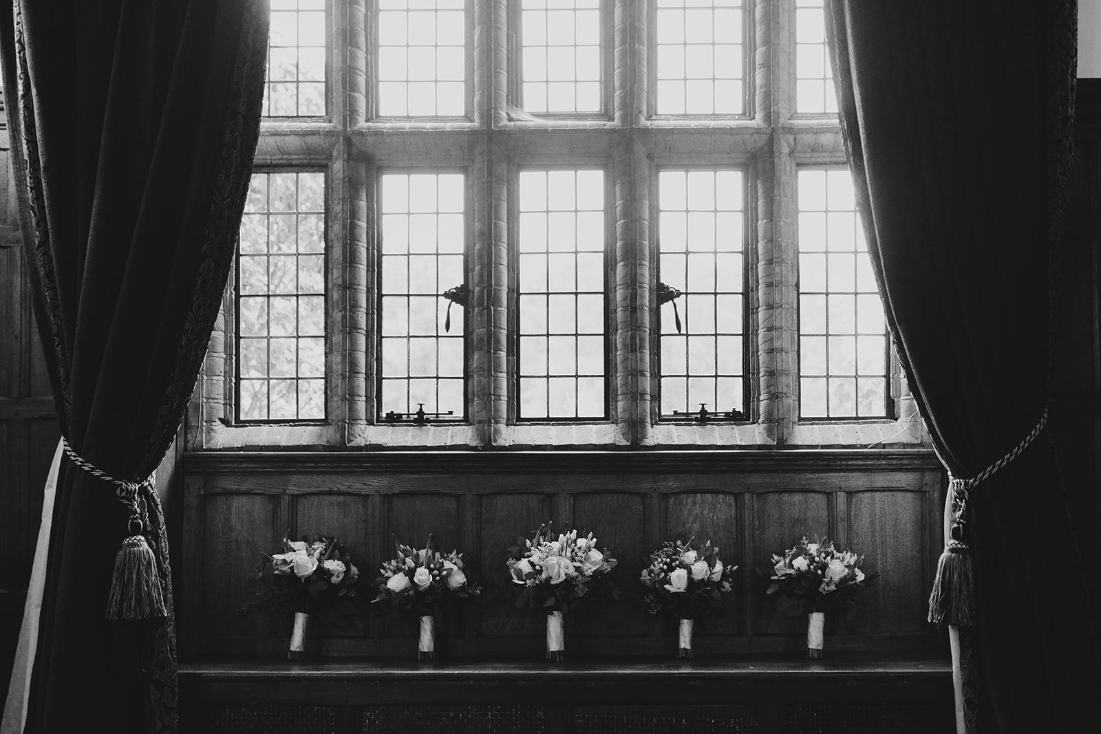 Wedding bouquets captured in front of windows at woodhall manor by Martin Beale