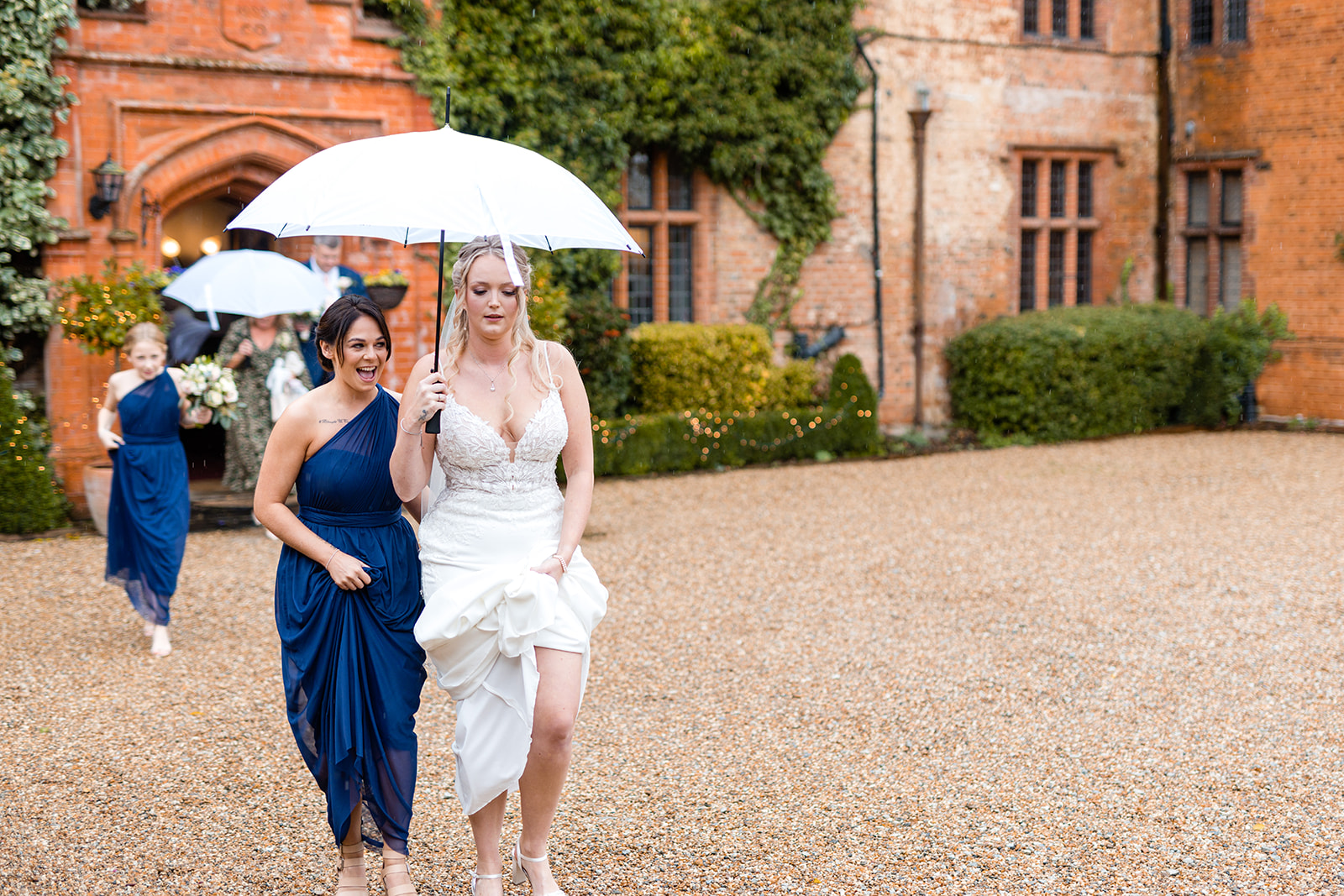 Bride walking in the rain at Woodhall Manor by Martin Beale Photography
