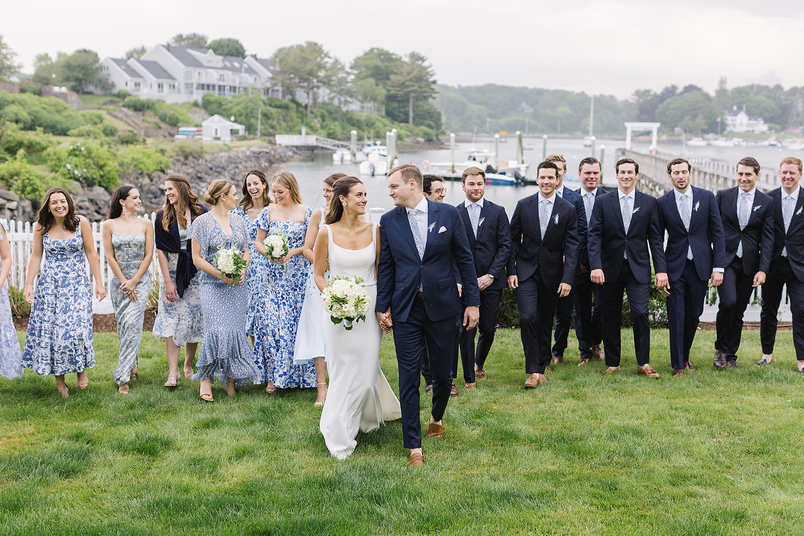 Wedding party photo: bride and groom with bridesmaids (mismatched dresses, including Reformation) and groomsmen before M