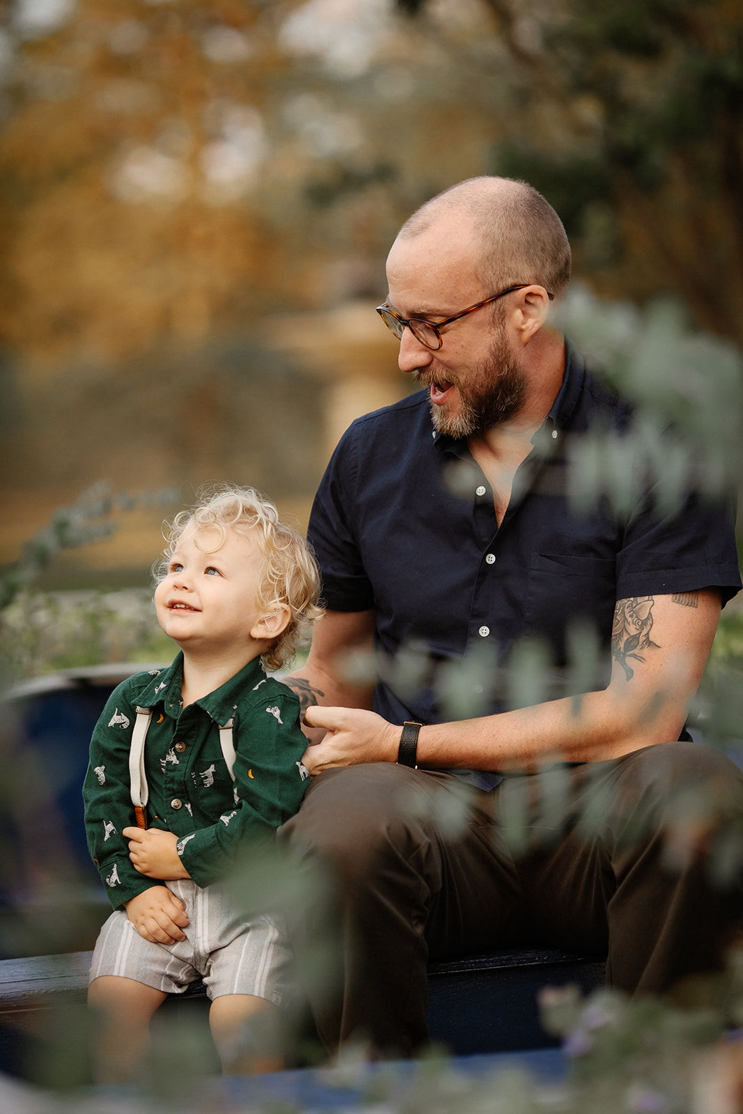 A sunset candid family session in Minneapolis with adorable little boy wearing suspenders.