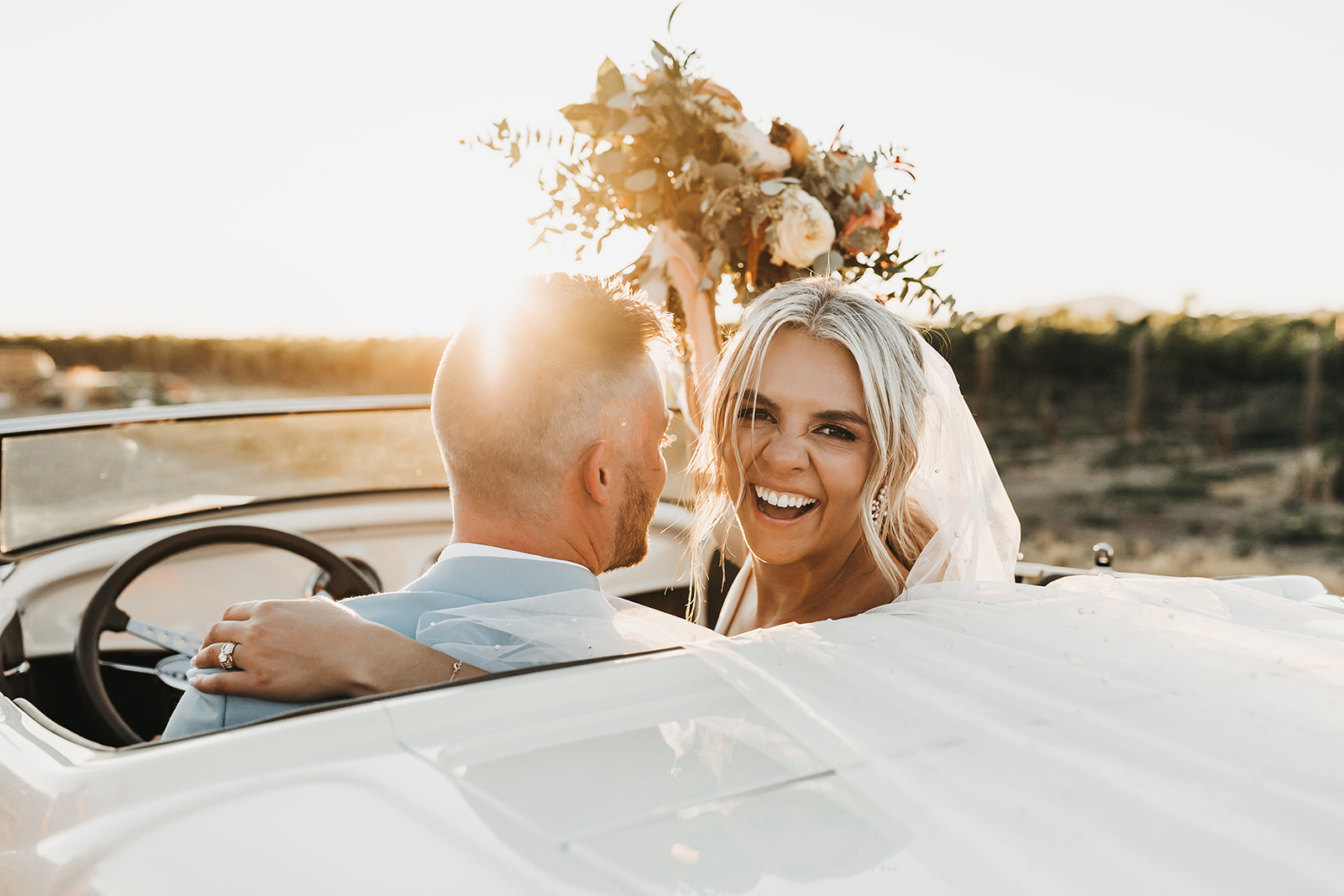Golden hour photos of bride and groom in a beautiful classic car
