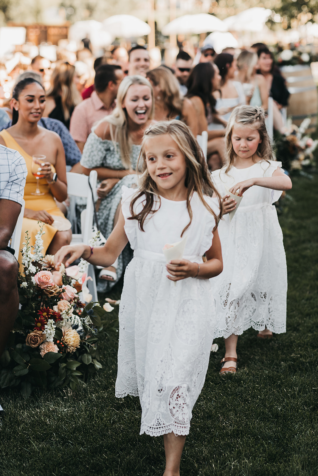 Flower girls walking down the aisle at winery wedding