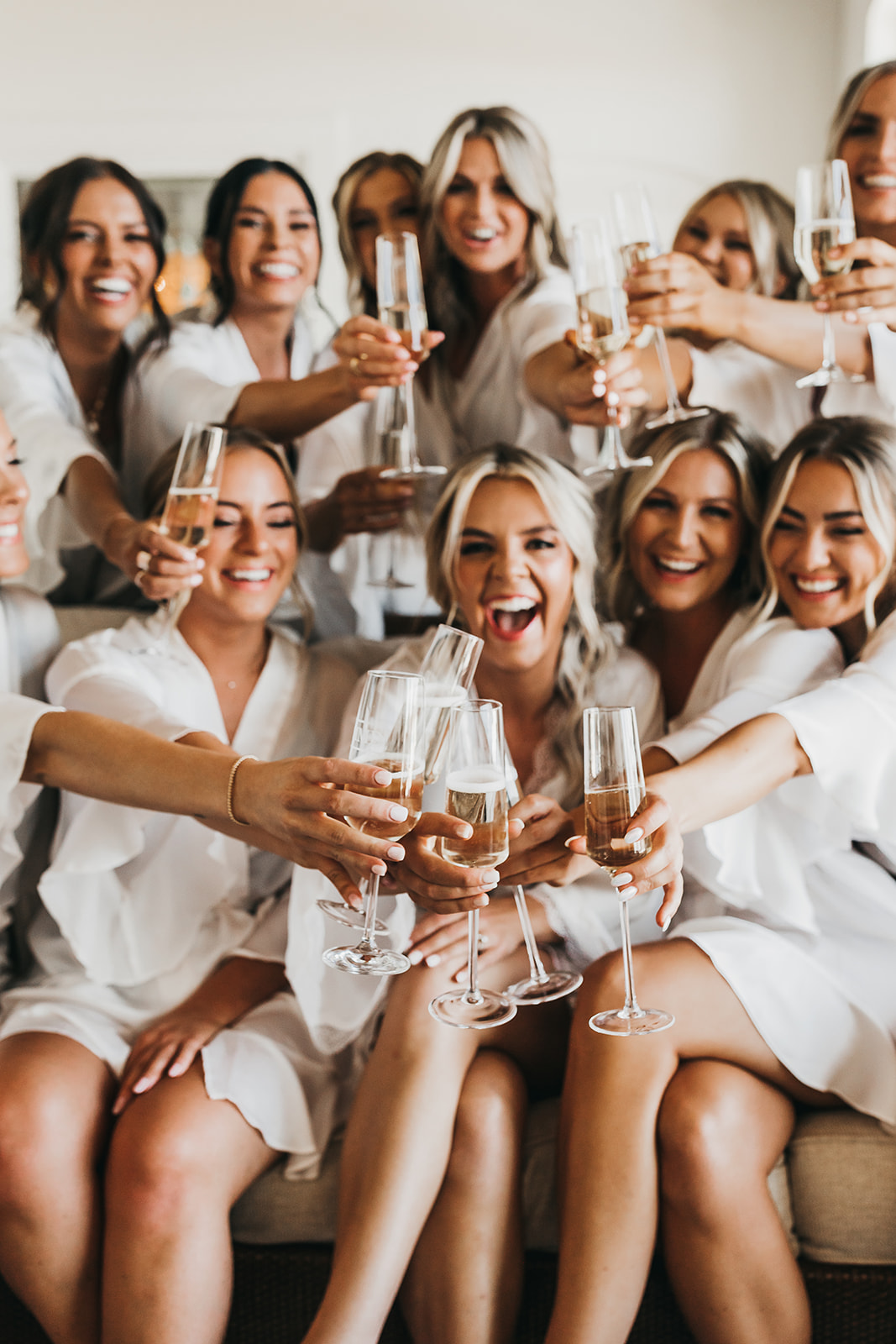 Bride and bridesmaids sharing a toast while getting ready for wedding