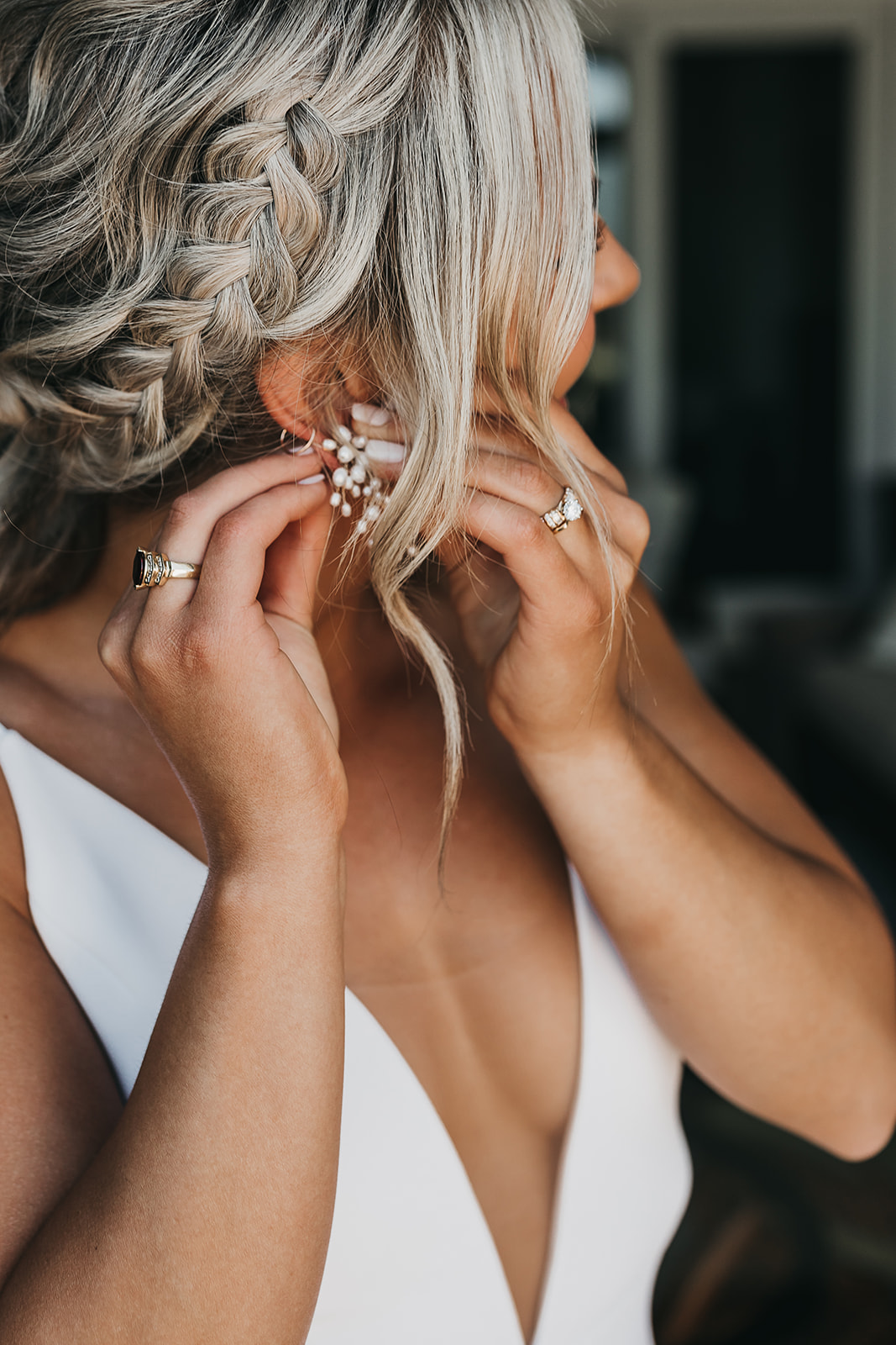 Bride putting on the finishing touches of jewelry before wedding ceremony 