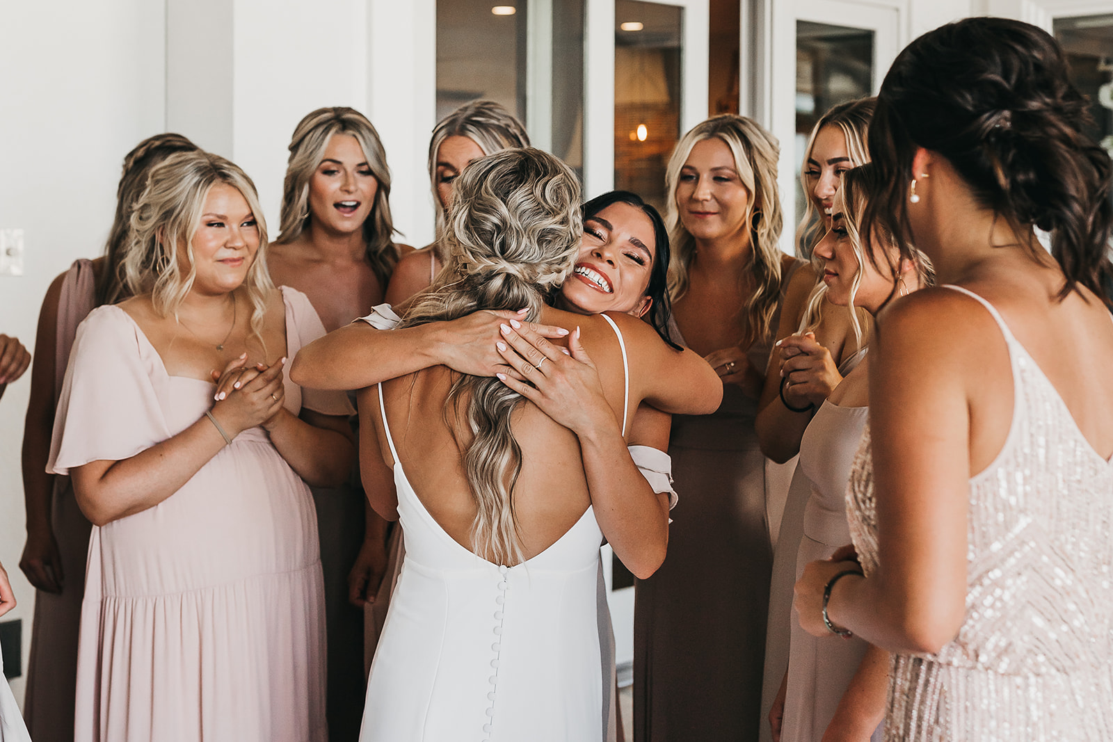 Bridesmaids sharing a special moment seeing the bride in her dress for the first time