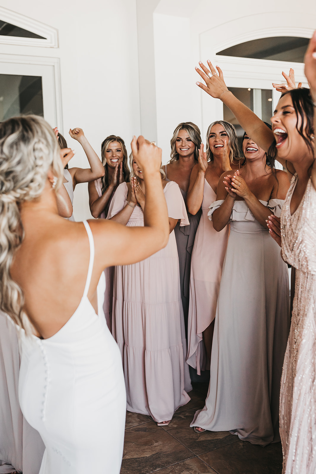 Bride and bridesmaids sharing laughs together before heading out to the wedding ceremony at winery