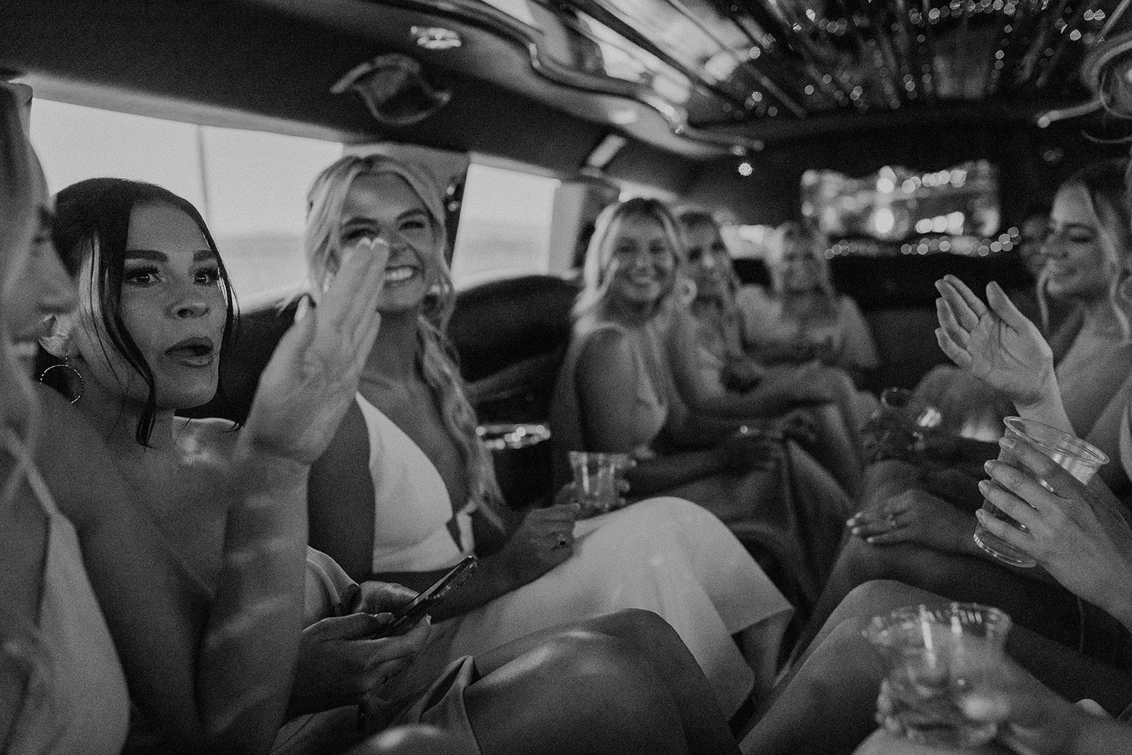 Bride and bridesmaids sharing laughs together on limo ride to Cooper Wine Company winery in Washington