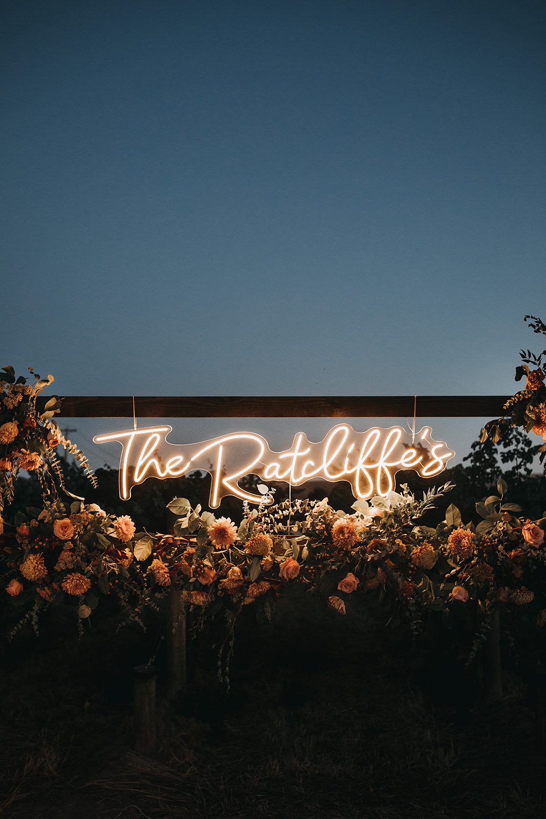 Stunning floral arraignments and LED sign of couples name lite up at wedding reception