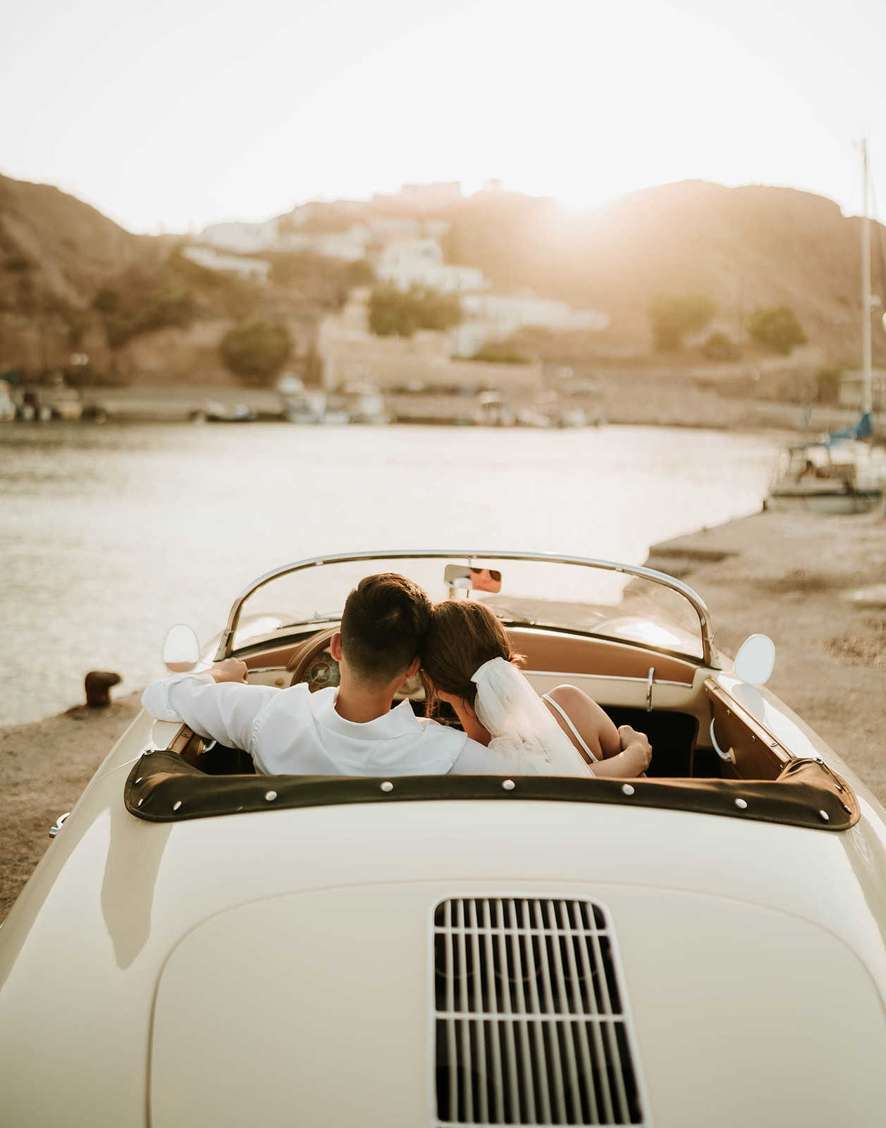 A couple who eloped in Santorini enjoyed the sunset in a vintage car