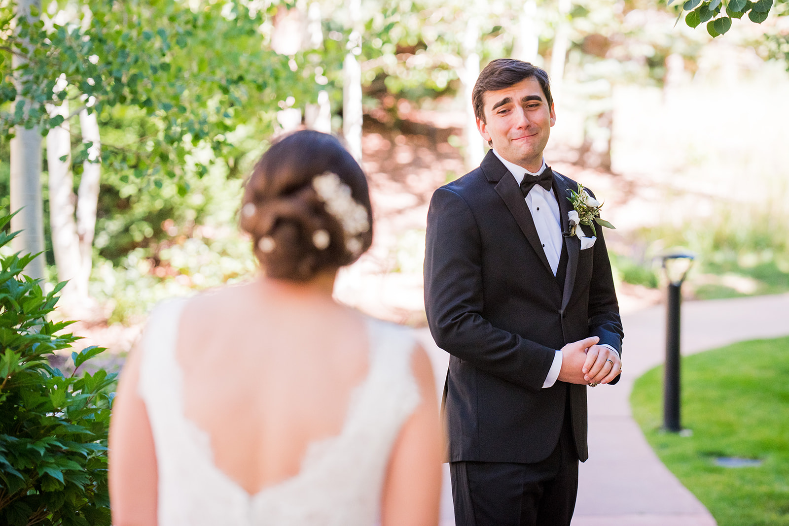 Groom gazes at bride with emotion during first look.