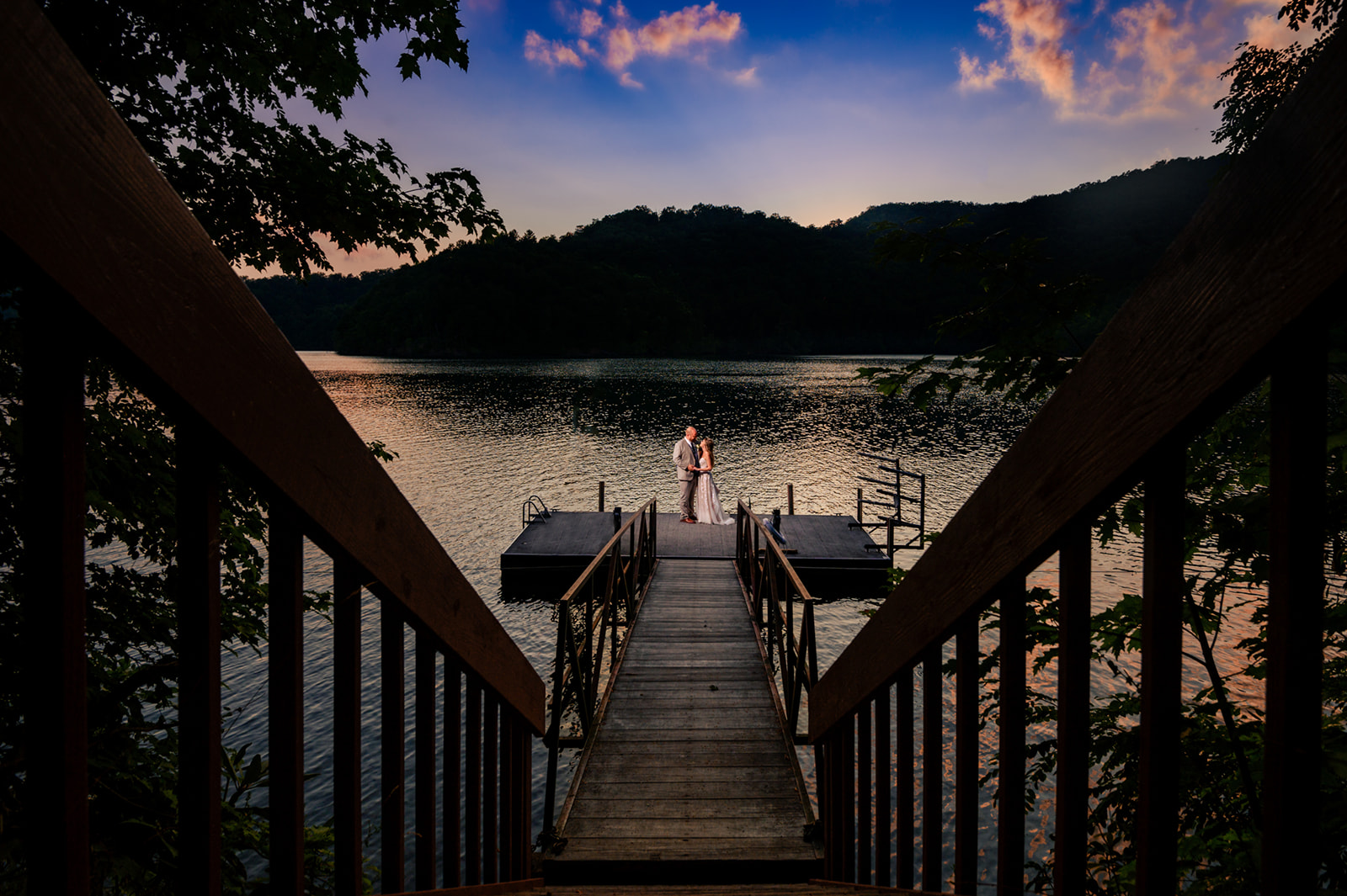wedding couple taking sunset photos at nantahala lake