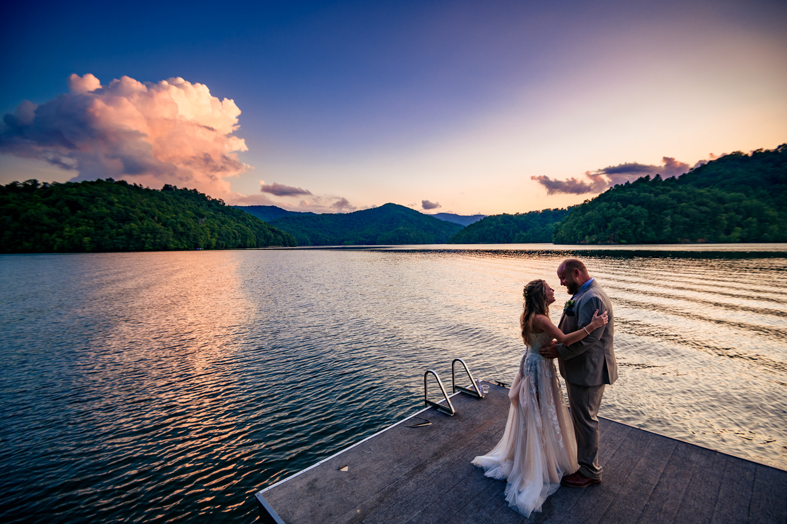 wedding couple taking sunset photos at nantahala lake