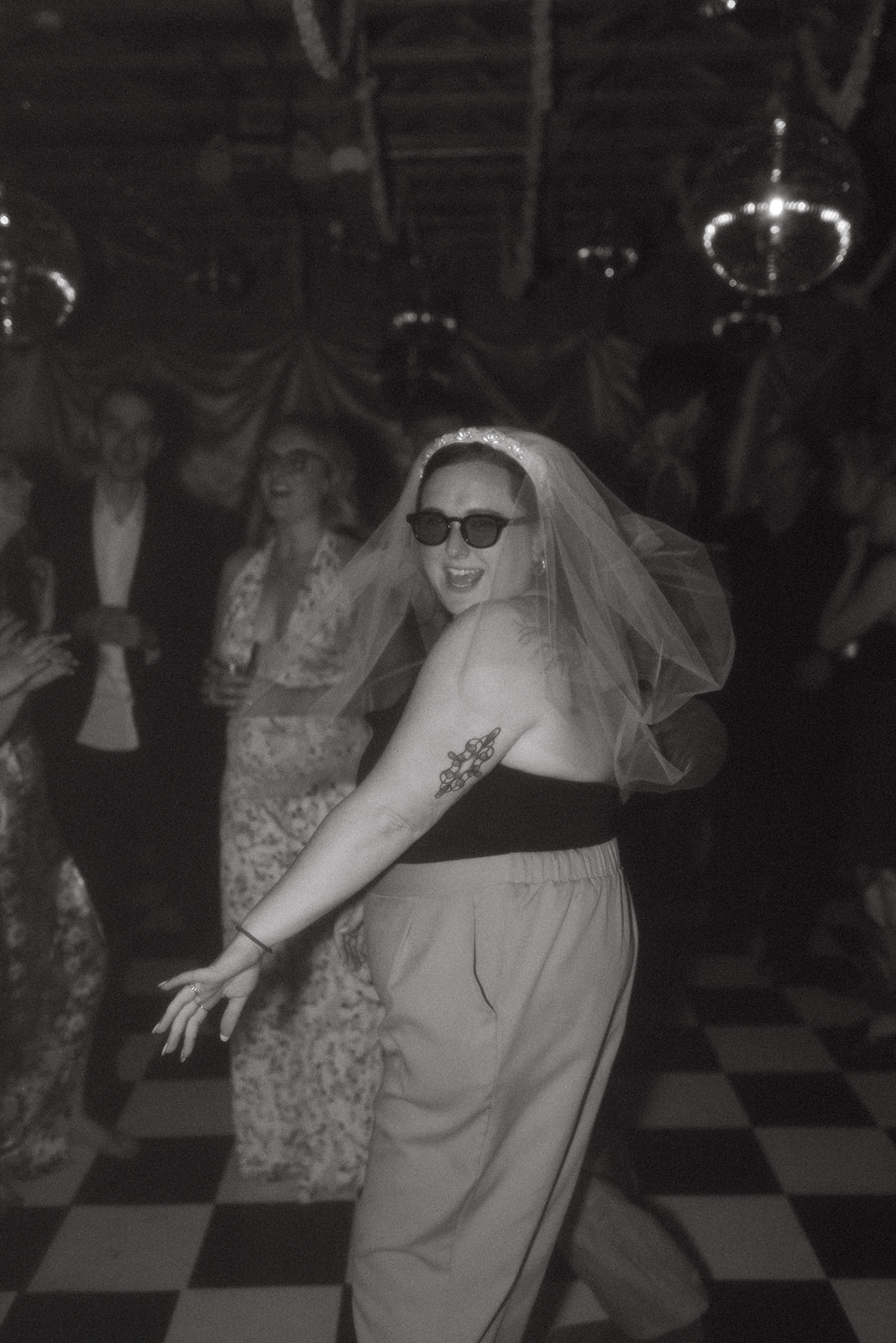 girl in veil and sunglasses at disco wedding