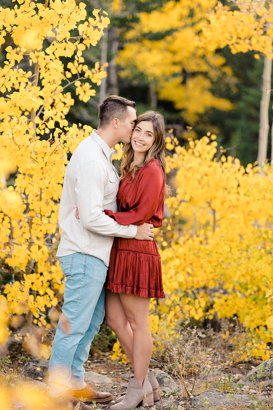 Colorado Fall engagement portrait of couple standing in front of yellow aspen trees in Brainard Lake