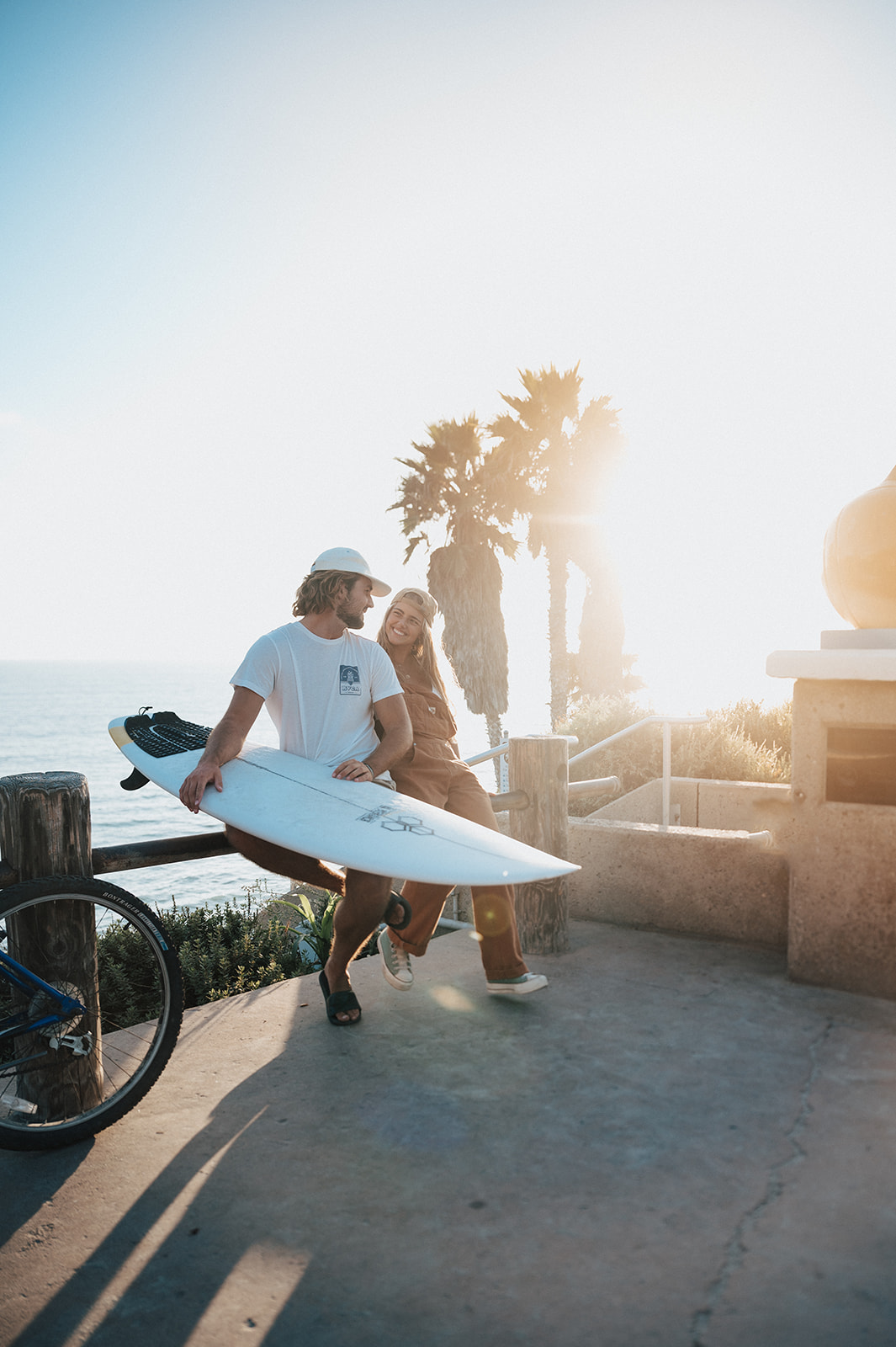 surfer couple hanging out before heading down to the beach at sunset