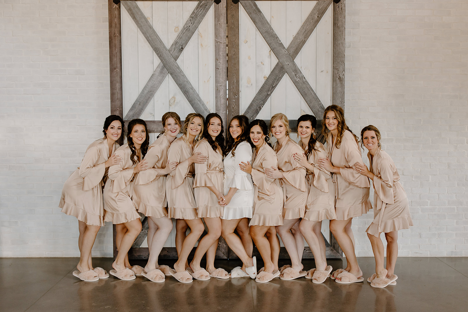 Bride and her bridesmaids snuggle up in their getting ready robes