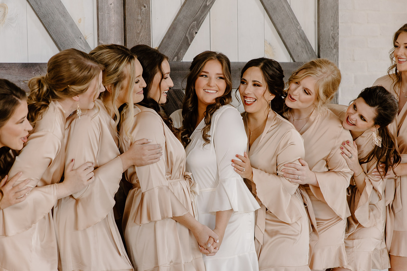 Bride and her bridesmaids snuggle up in their getting ready robes