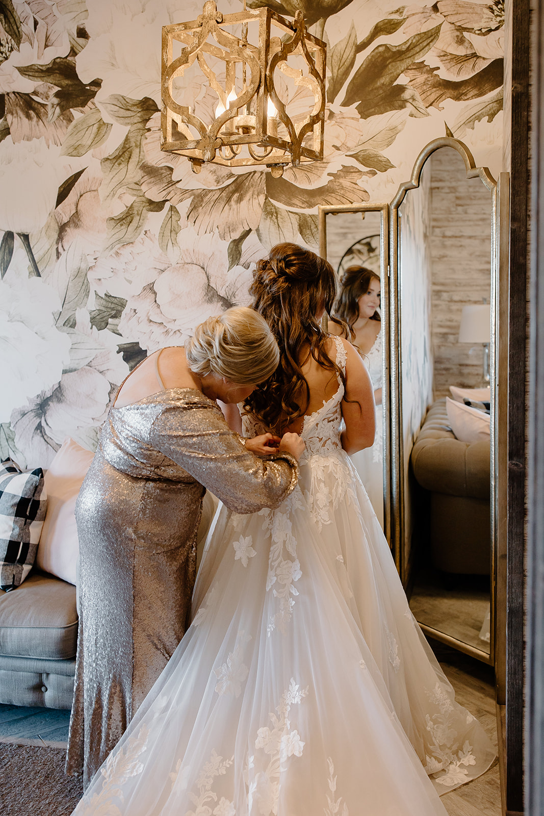 Mother zips her daughter's wedding dress
