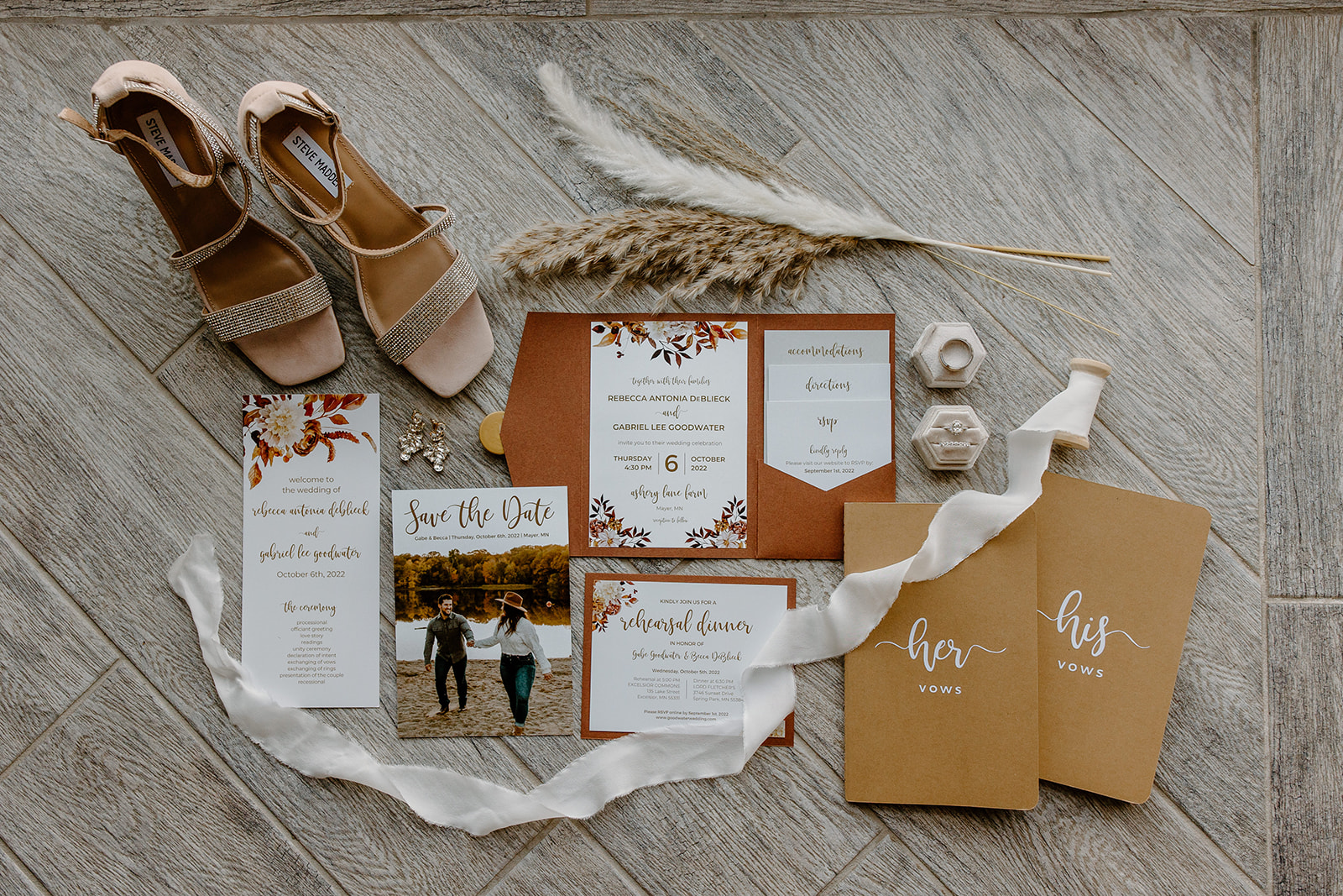 Flat lay of wedding invitations, rings, jewelry, and other details