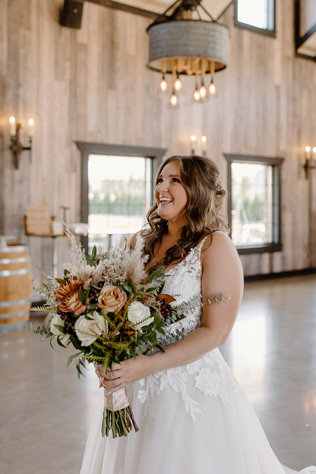Bride smiles up at her bridesmaids while holding her bouquet