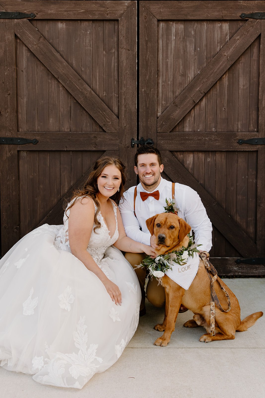 Bride and groom smile with their dog