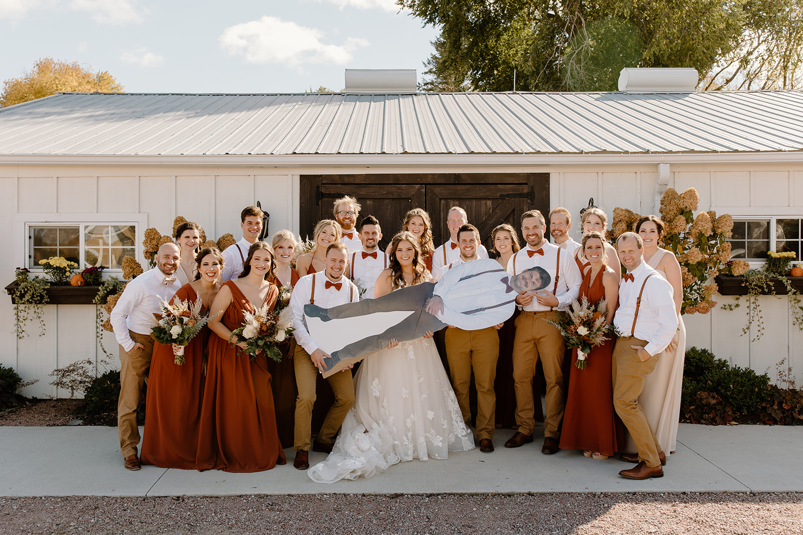 Wedding party hold up a cardboard cut out of a groomsmen