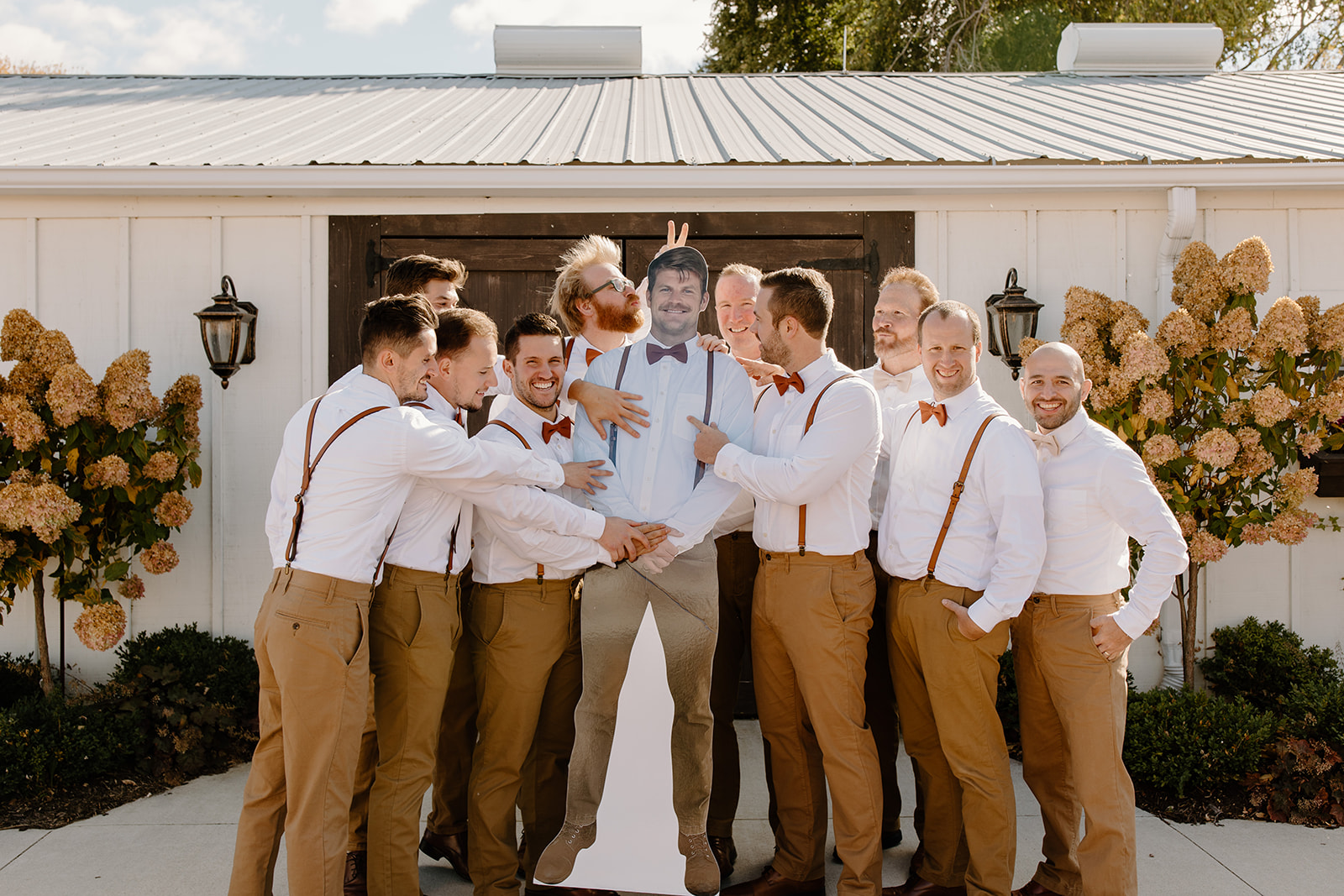 Groomsmen hold up a cardboard cut out of a groomsmen