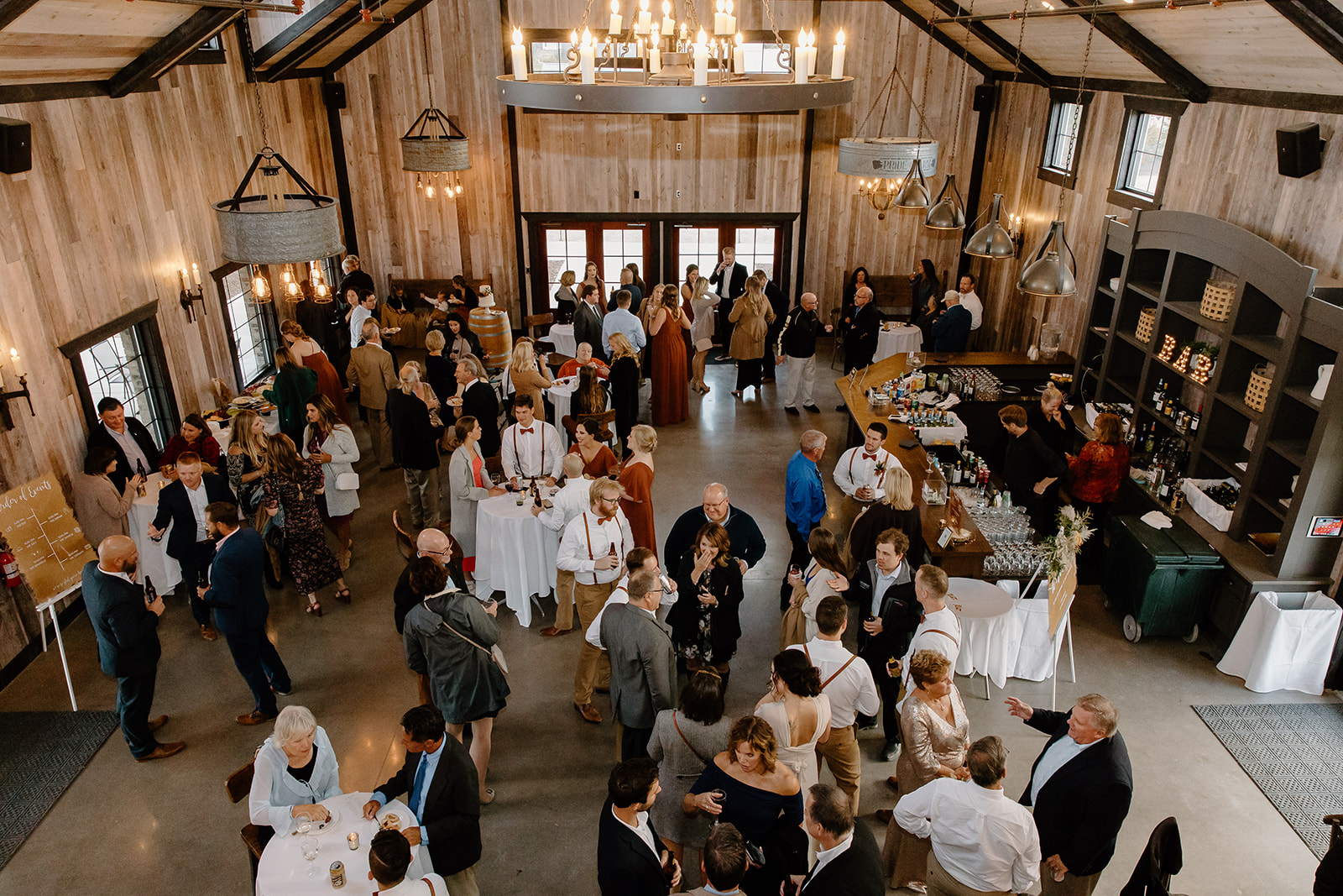 Guests enjoy cocktail hour inside of a barn