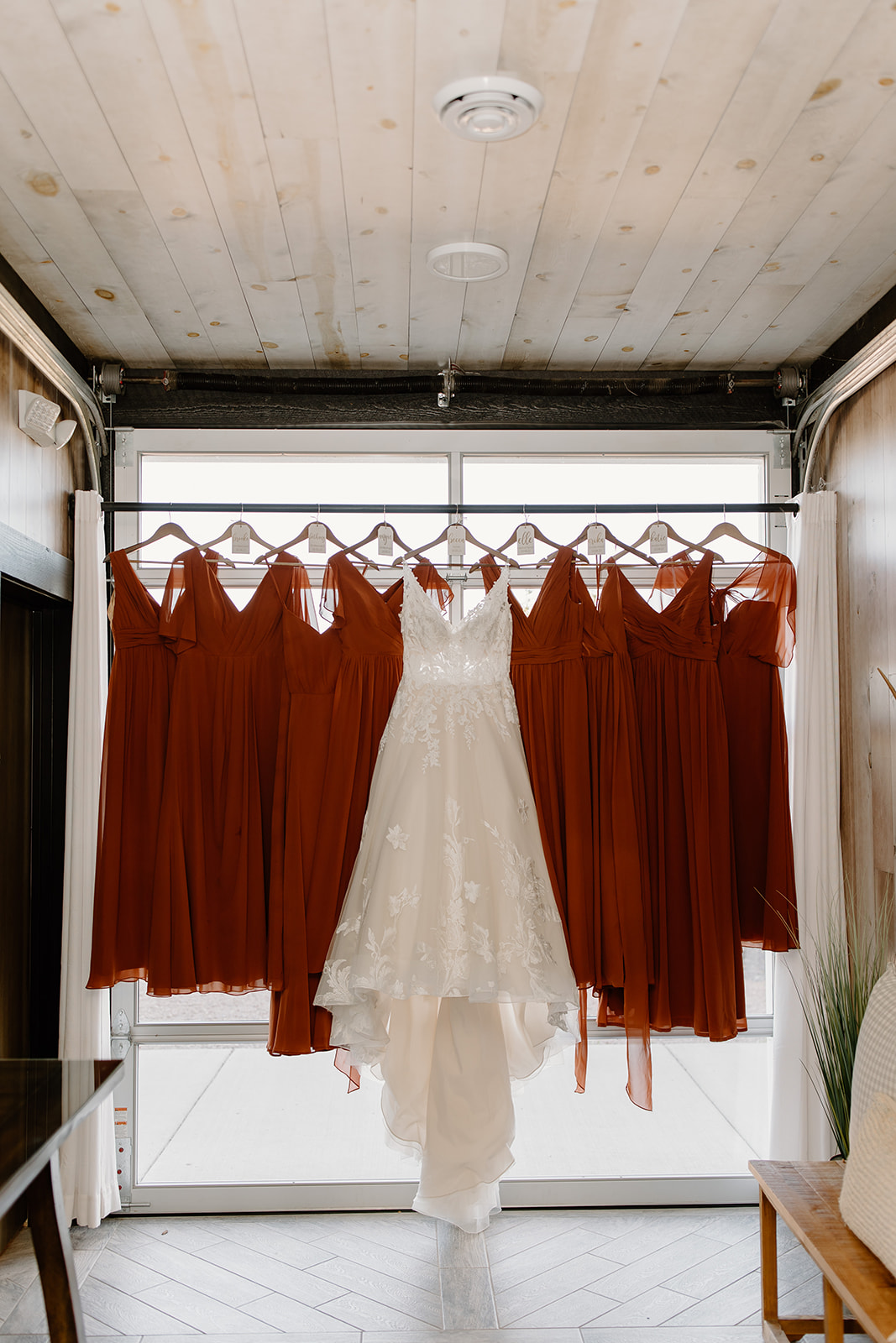 Bride's dress hanging with the bridesmaid dresses