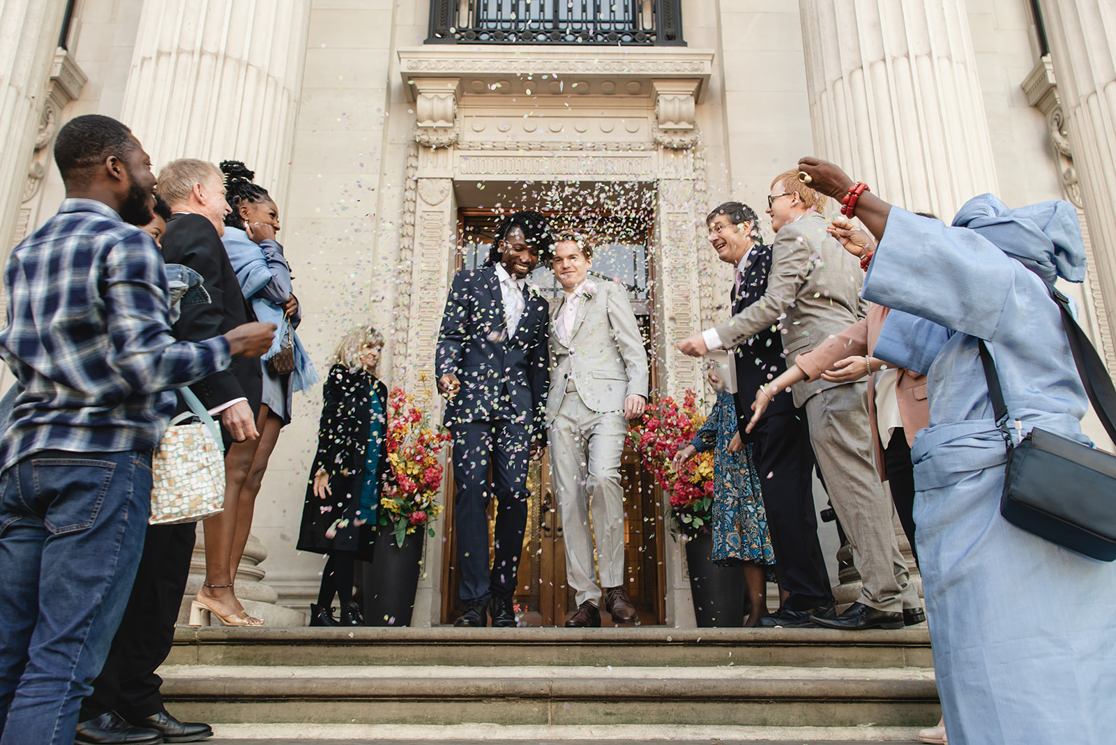 Benjamin and Ezekiel welcomed by guest with confetti toss at Marylebone Town Hall